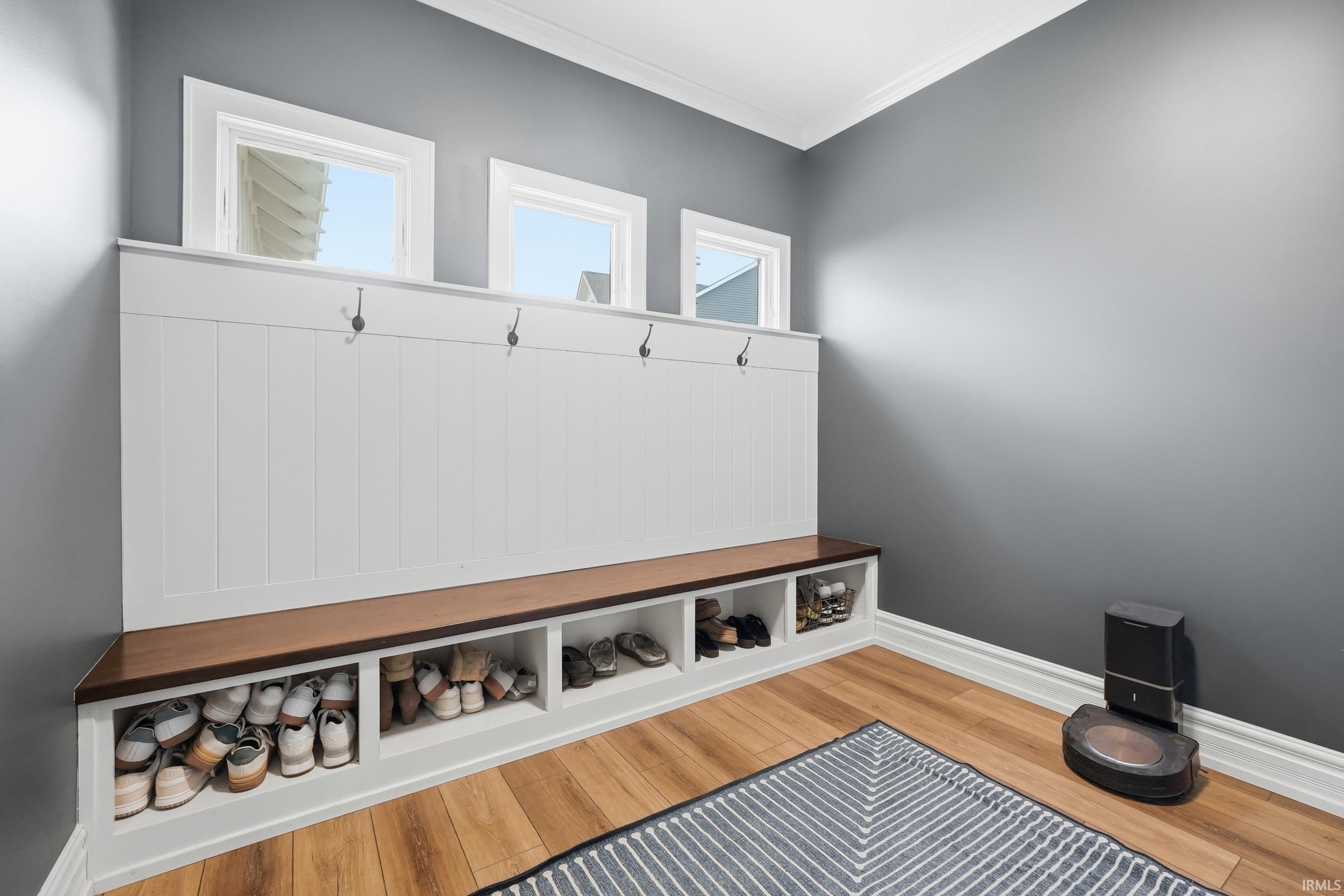 Built-in storage bench featuring a wood-finish top, white paneled backing, and integrated cubbies