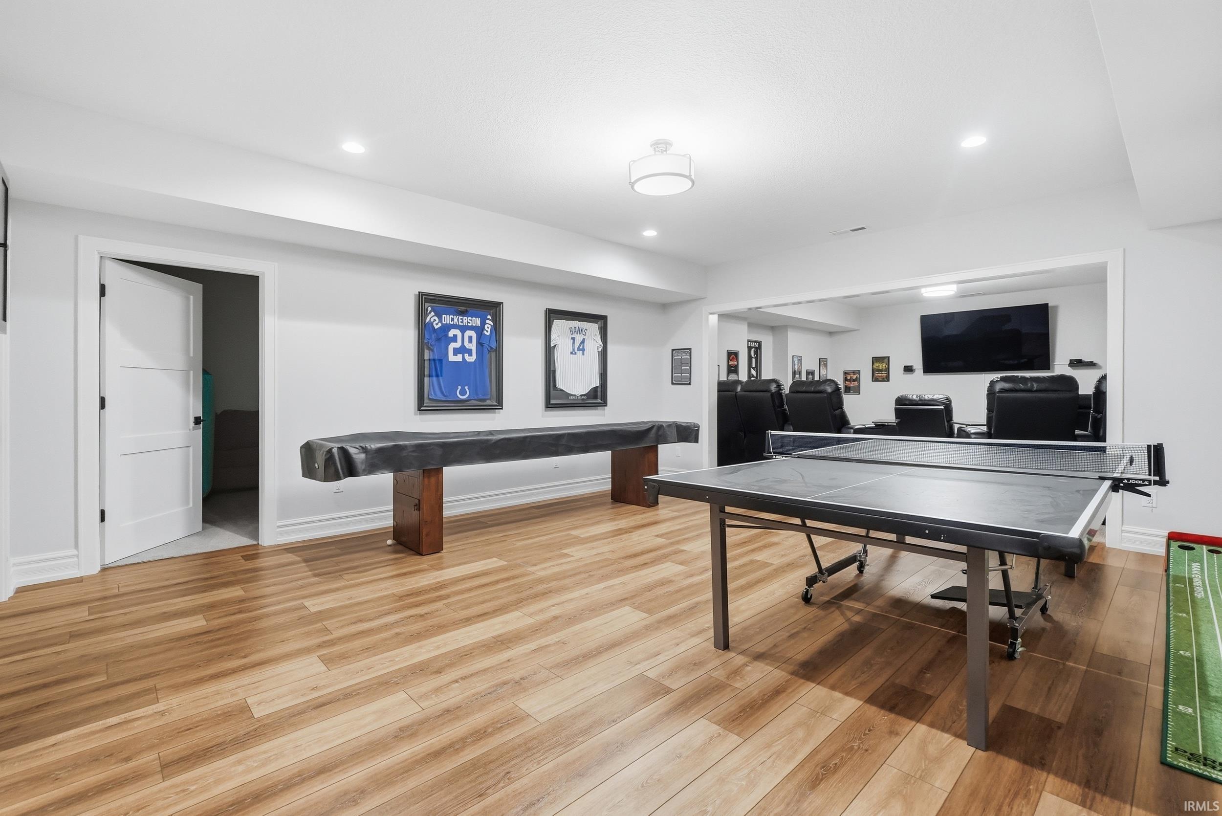Spacious recreation room featuring wood-finish flooring and recessed lighting
