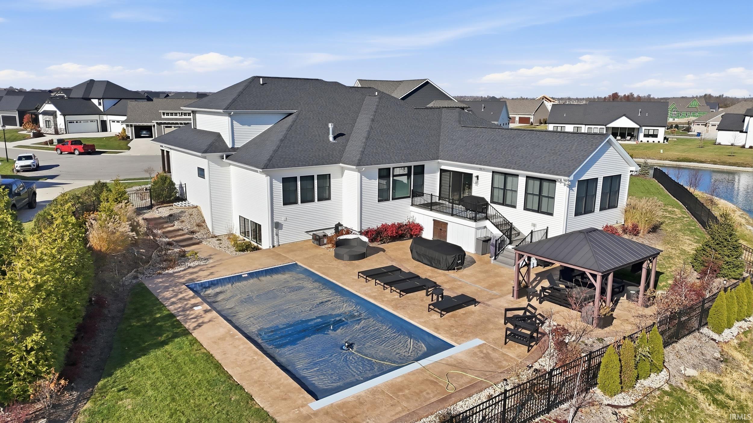 White exterior residence featuring a dark shingle roof and black-framed windows