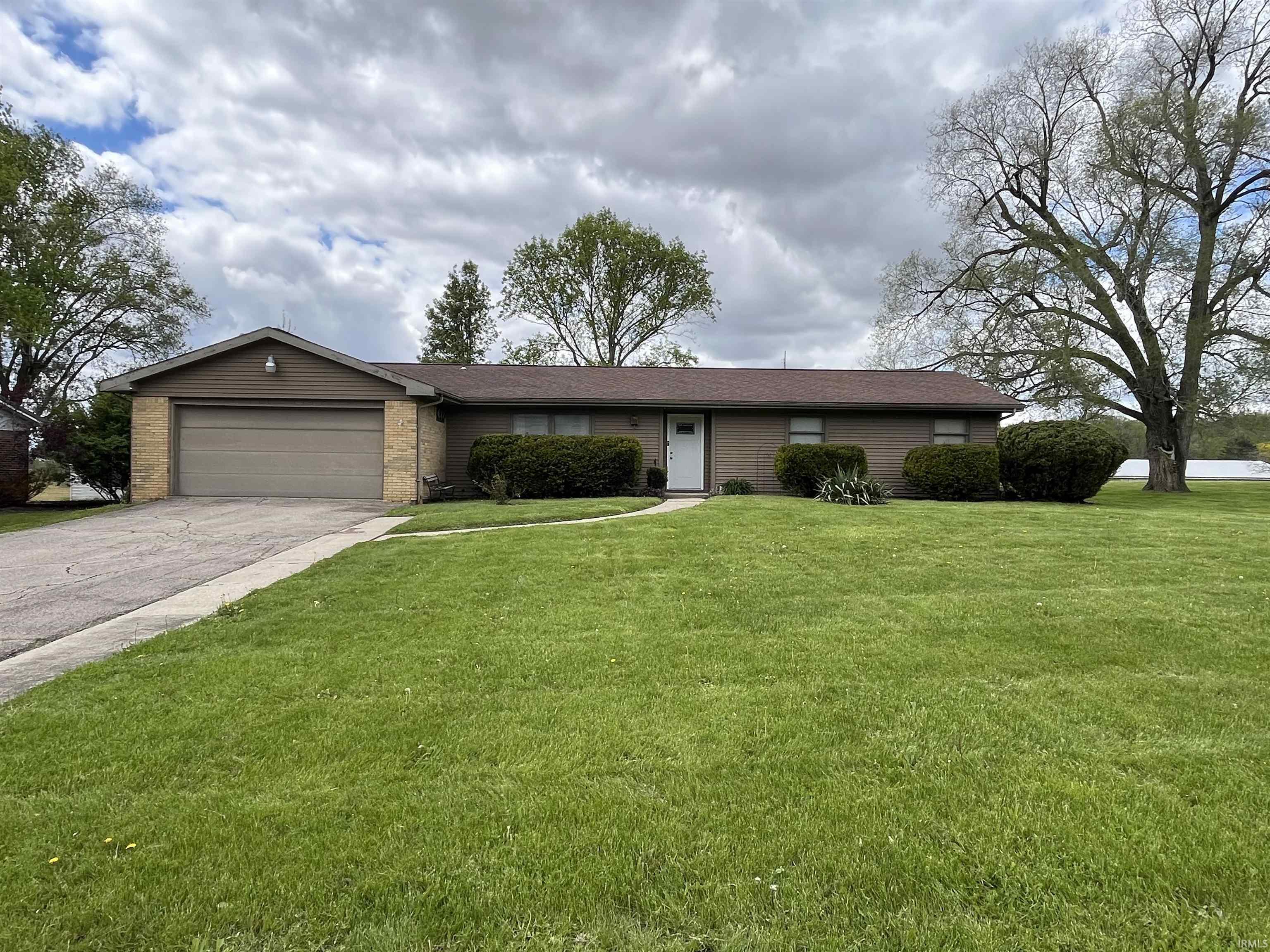 Ranch-style exterior with a single-car garage, brick accents, and a front entry door
