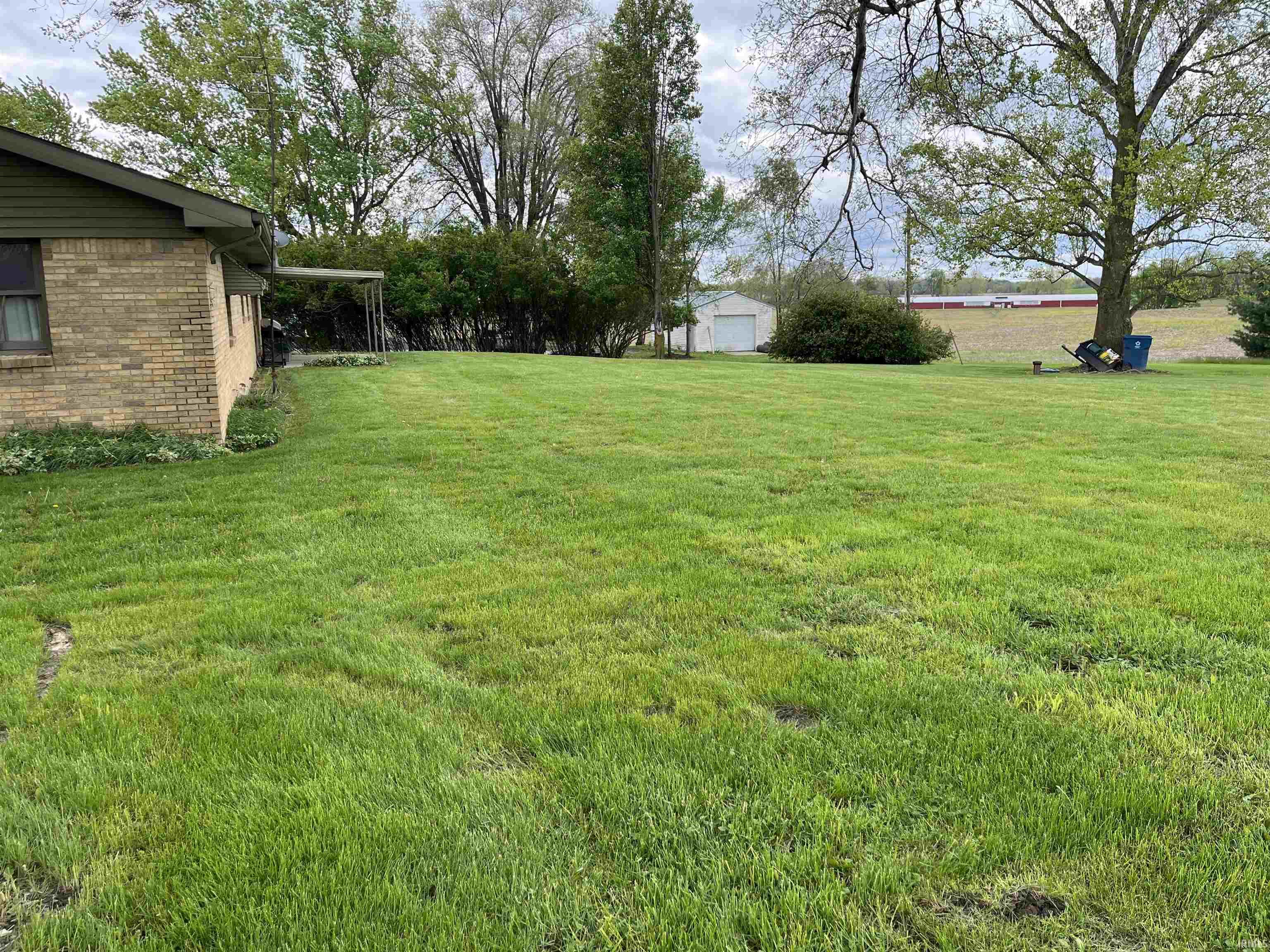 Expansive green lawn bordering a brick exterior residence