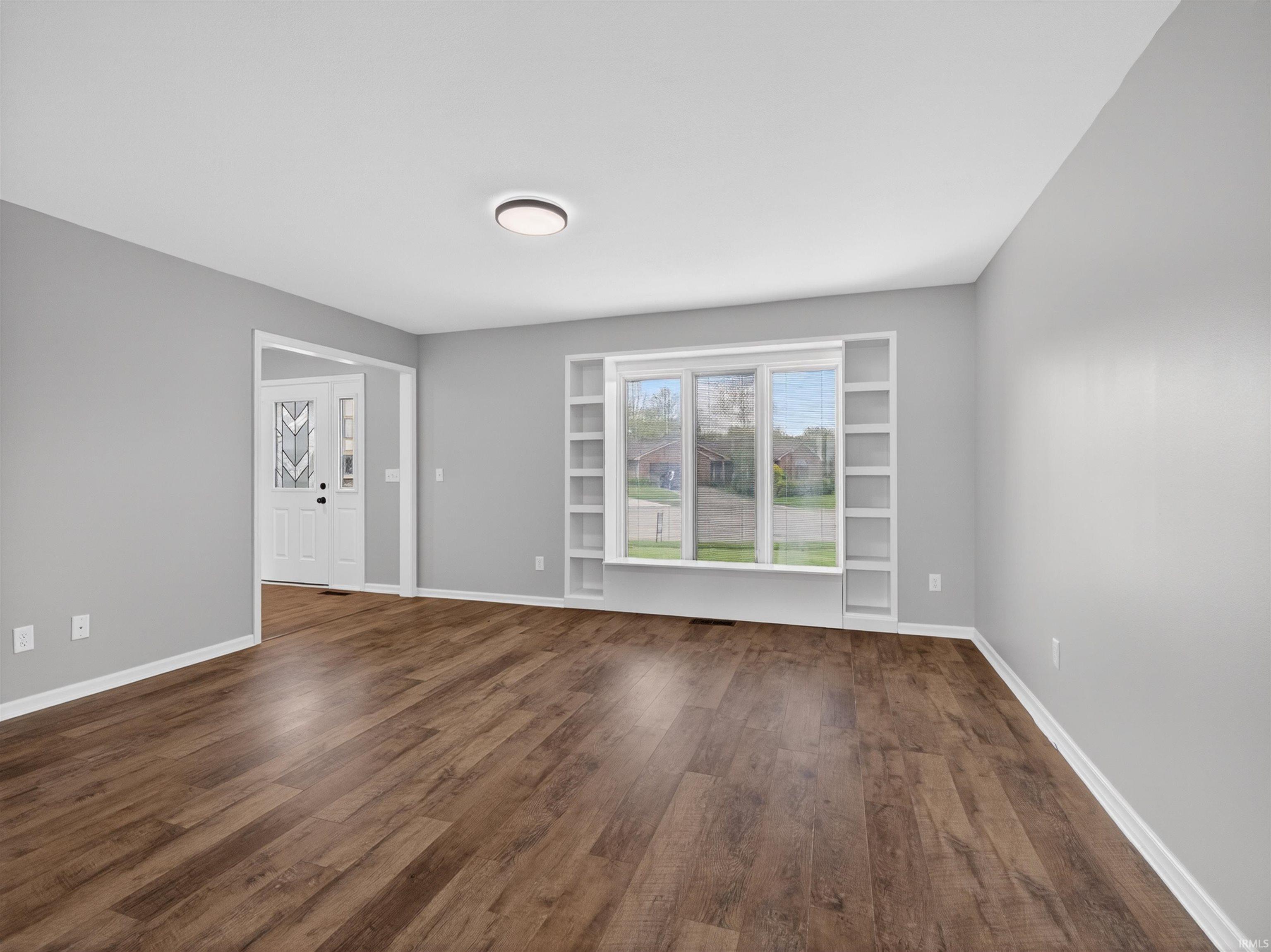 Spacious room featuring wood-finish flooring and light gray wall color