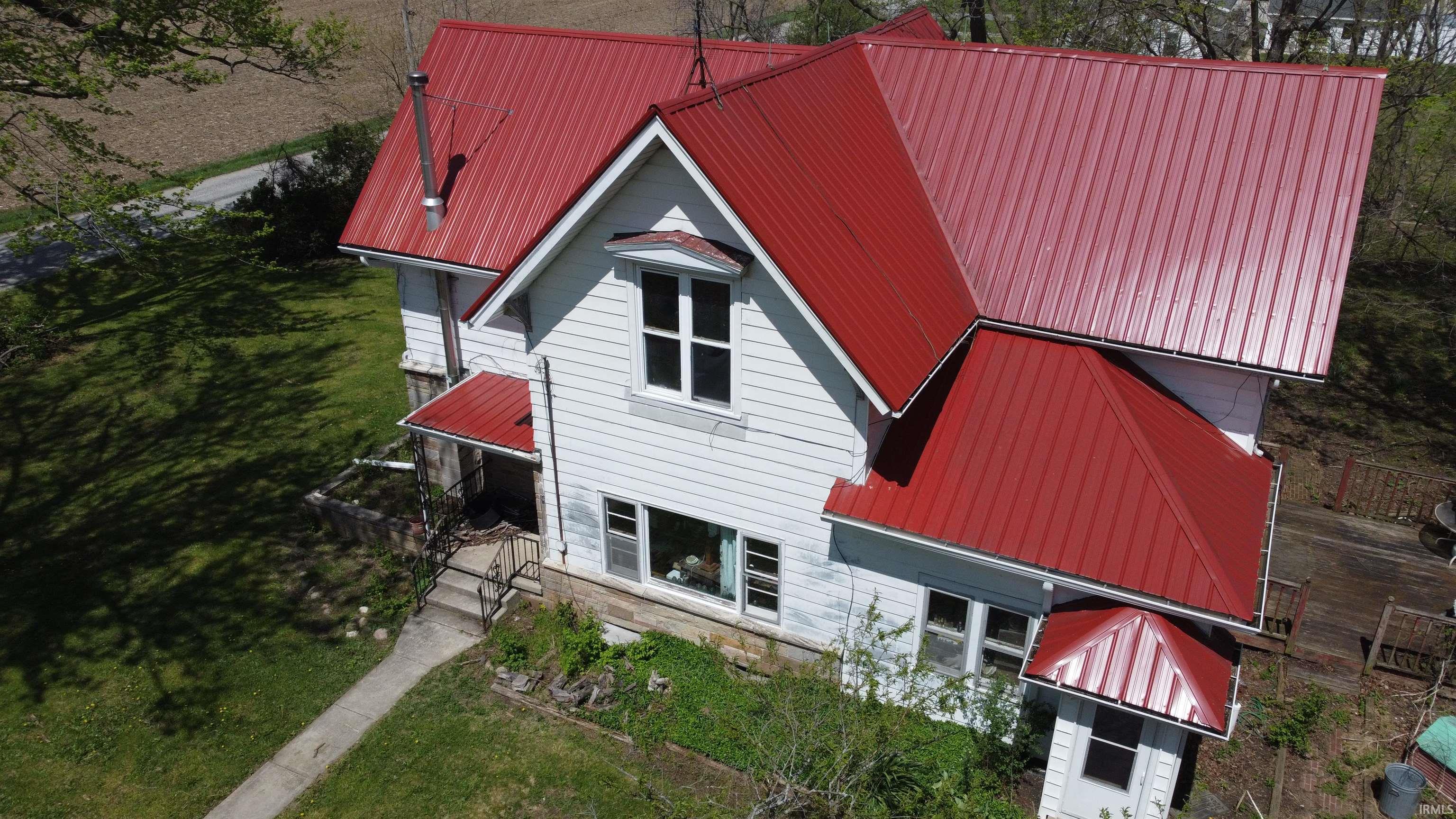White-sided residence featuring a prominent red metal roof