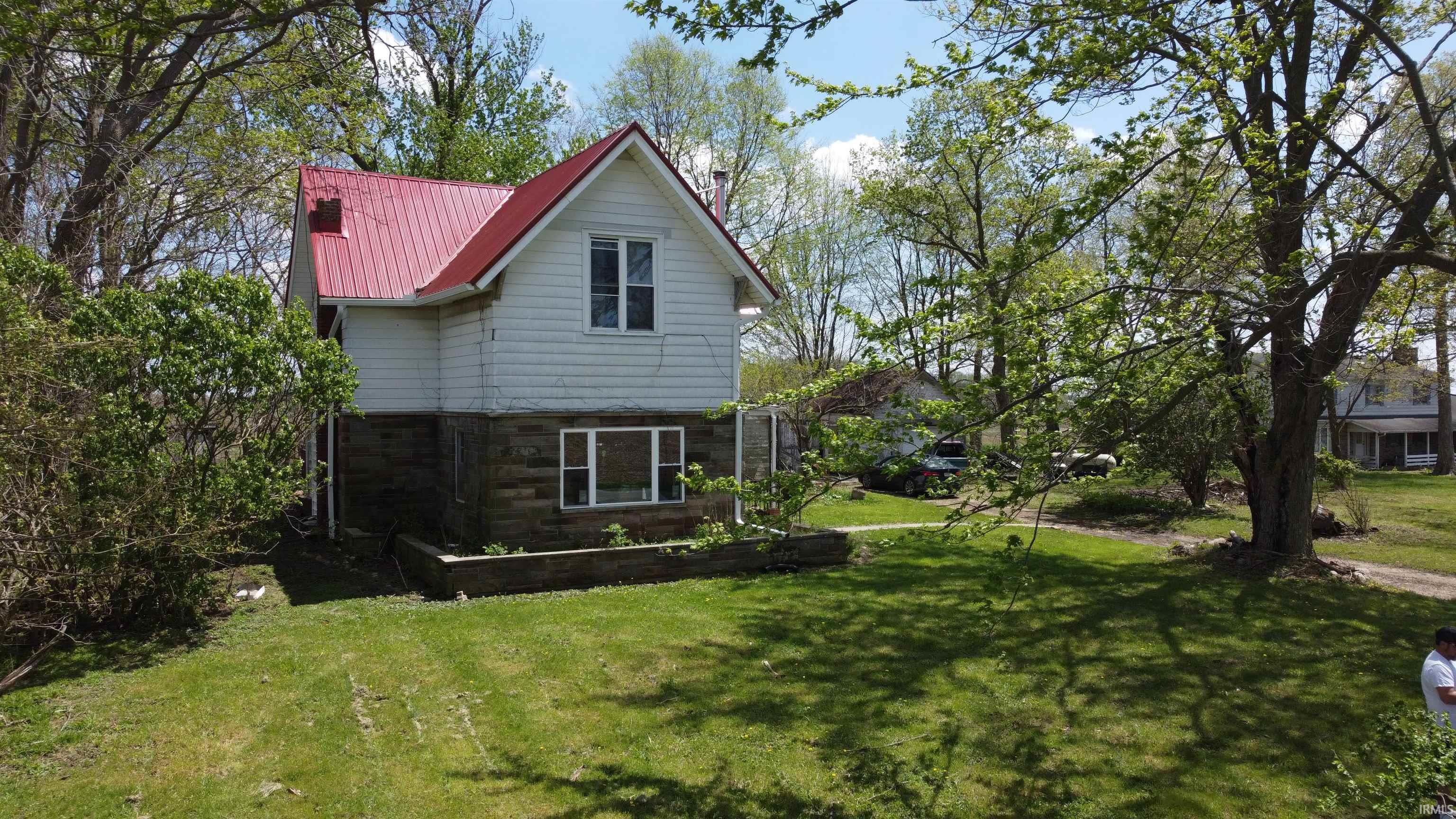 Two-story dwelling with white siding and a red metal roof
