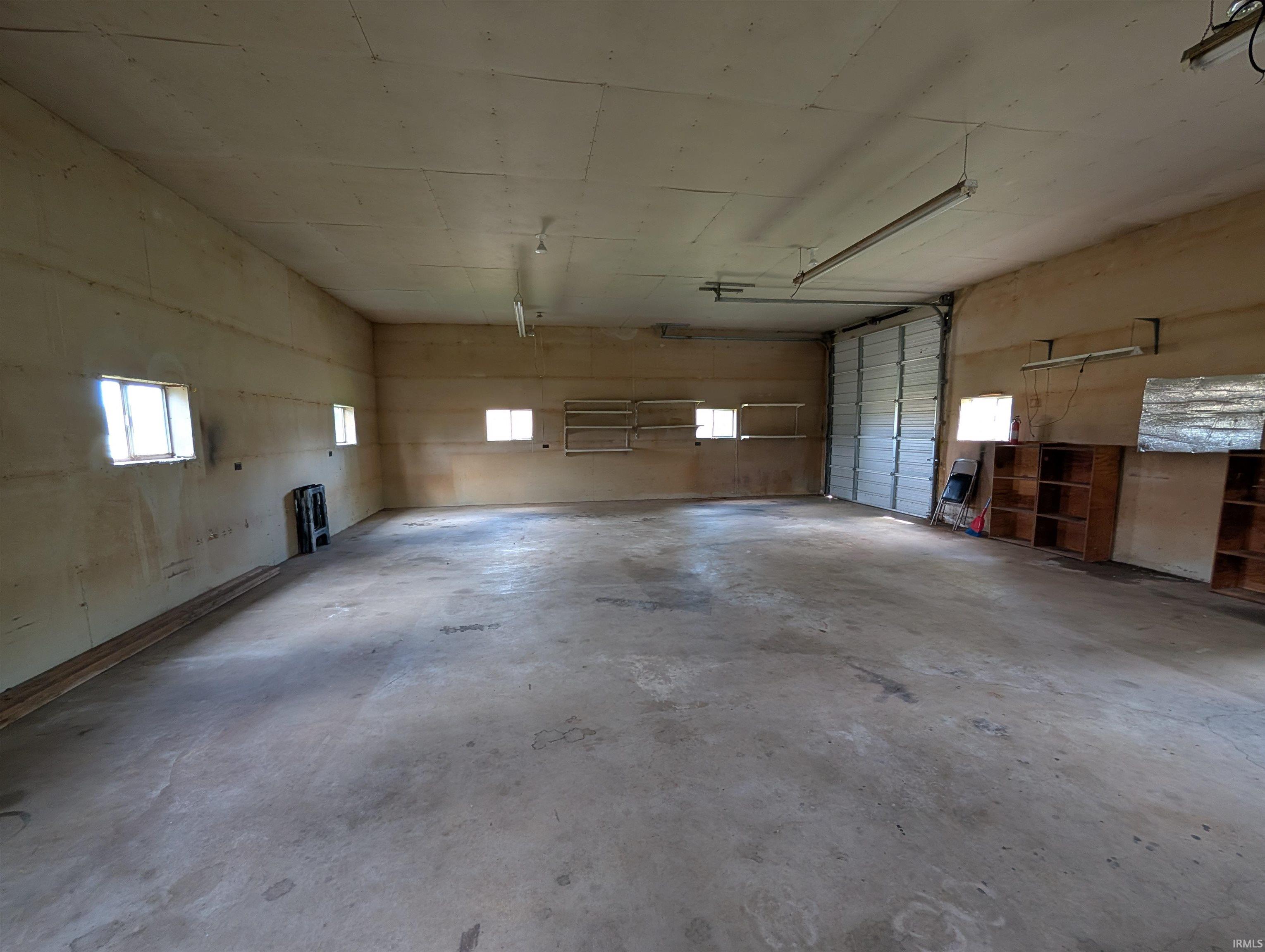 Spacious interior with concrete flooring and multiple windows providing natural light