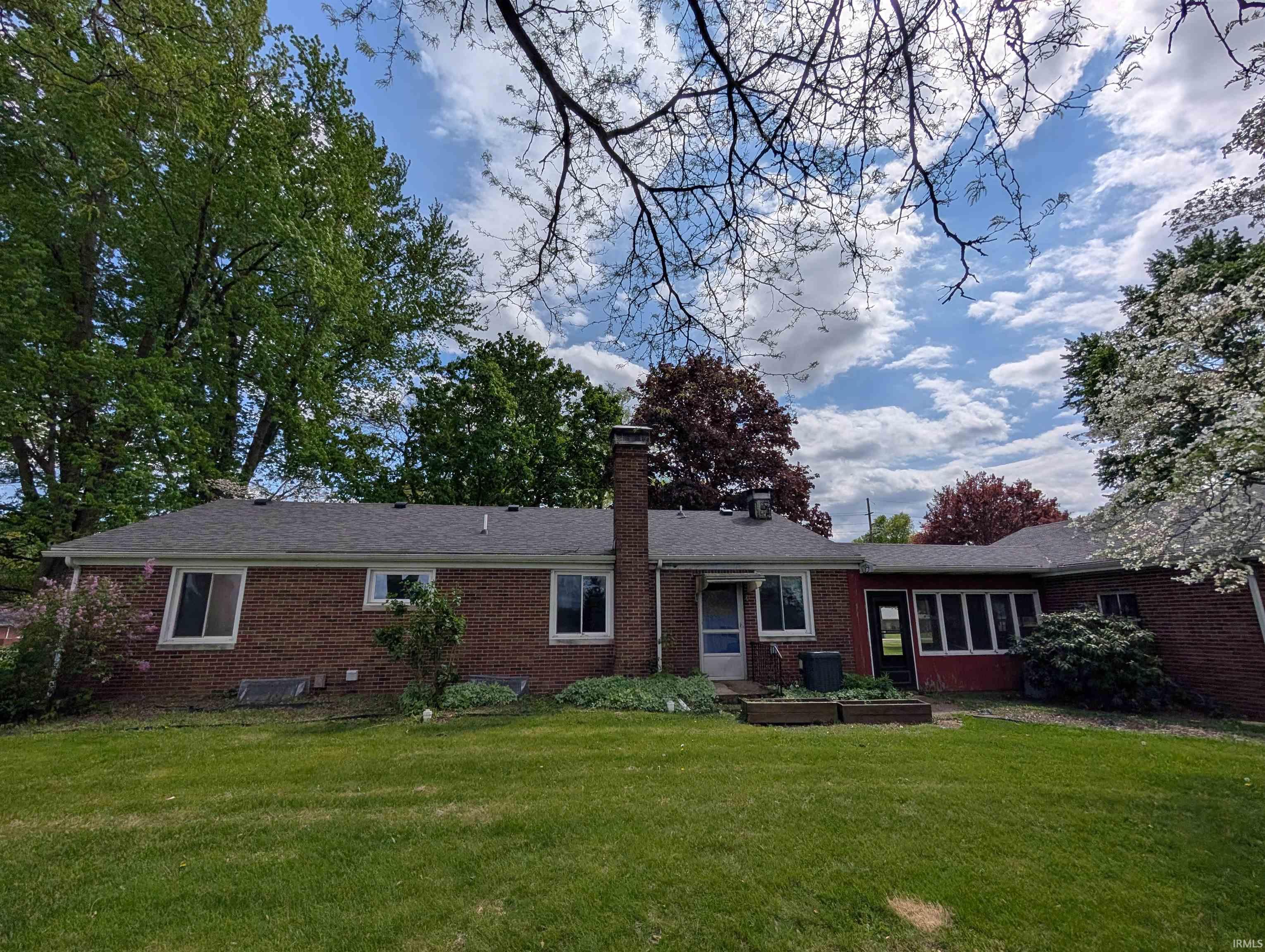Brick exterior featuring a screened-in porch and an attached sunroom
