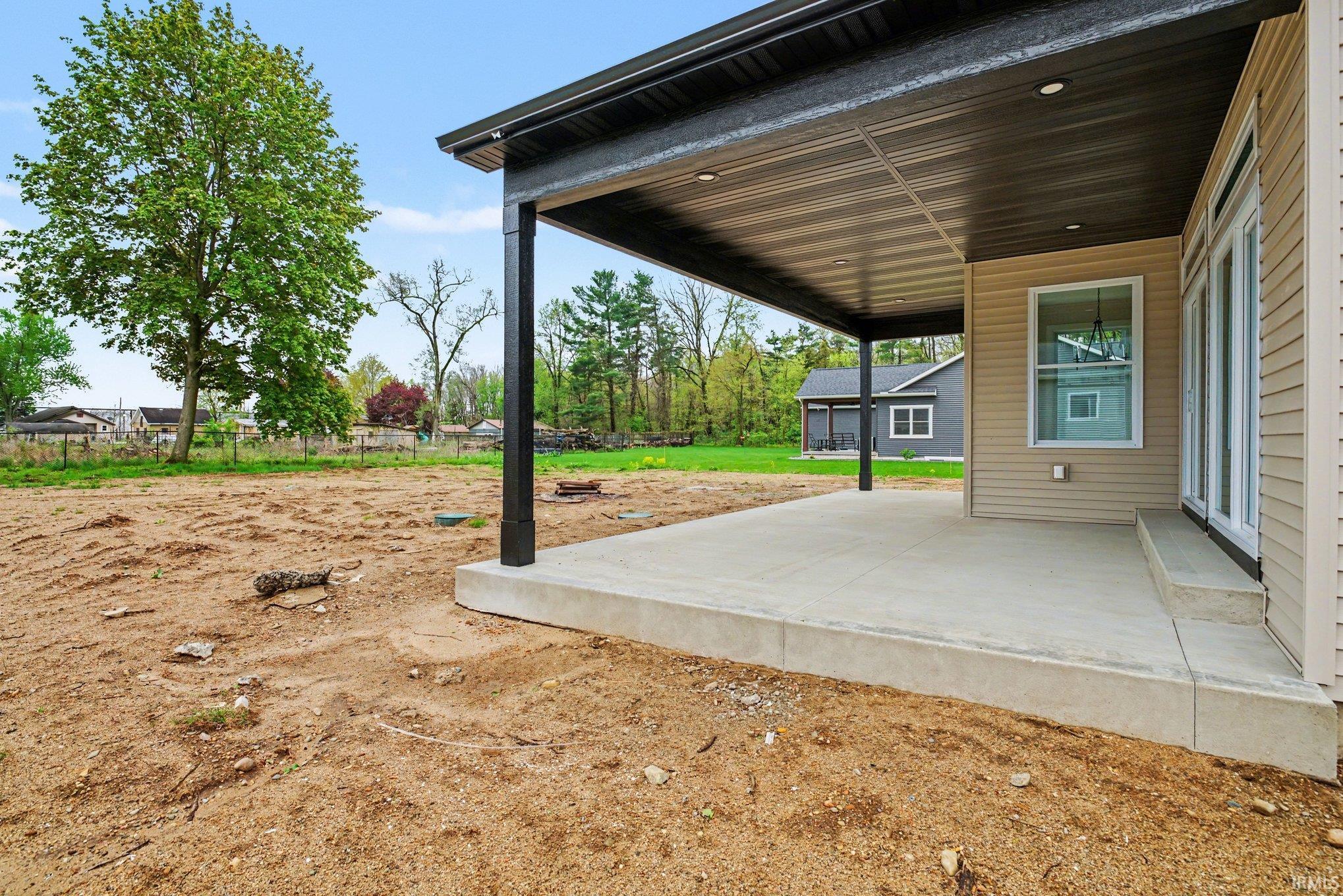 Expansive covered patio featuring a concrete surface, recessed lighting, and a dark metal ceiling