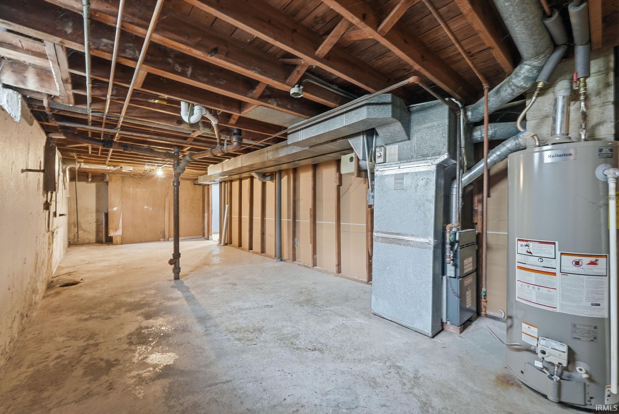 Unfinished basement with concrete flooring and exposed ceiling joists