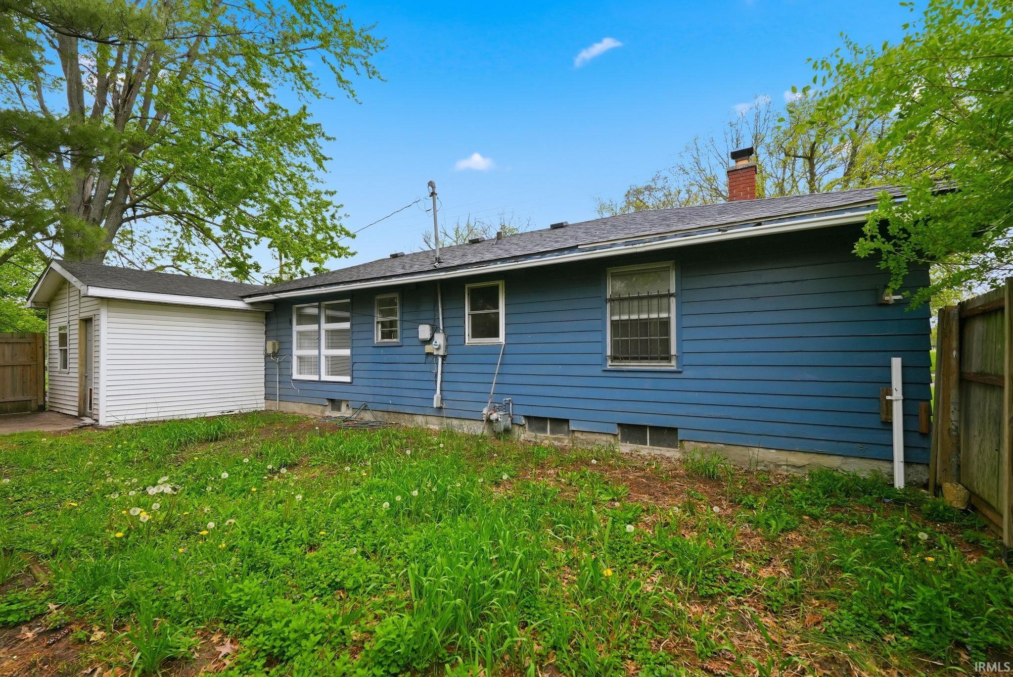Blue siding exterior with white trim windows and a detached white vinyl garage