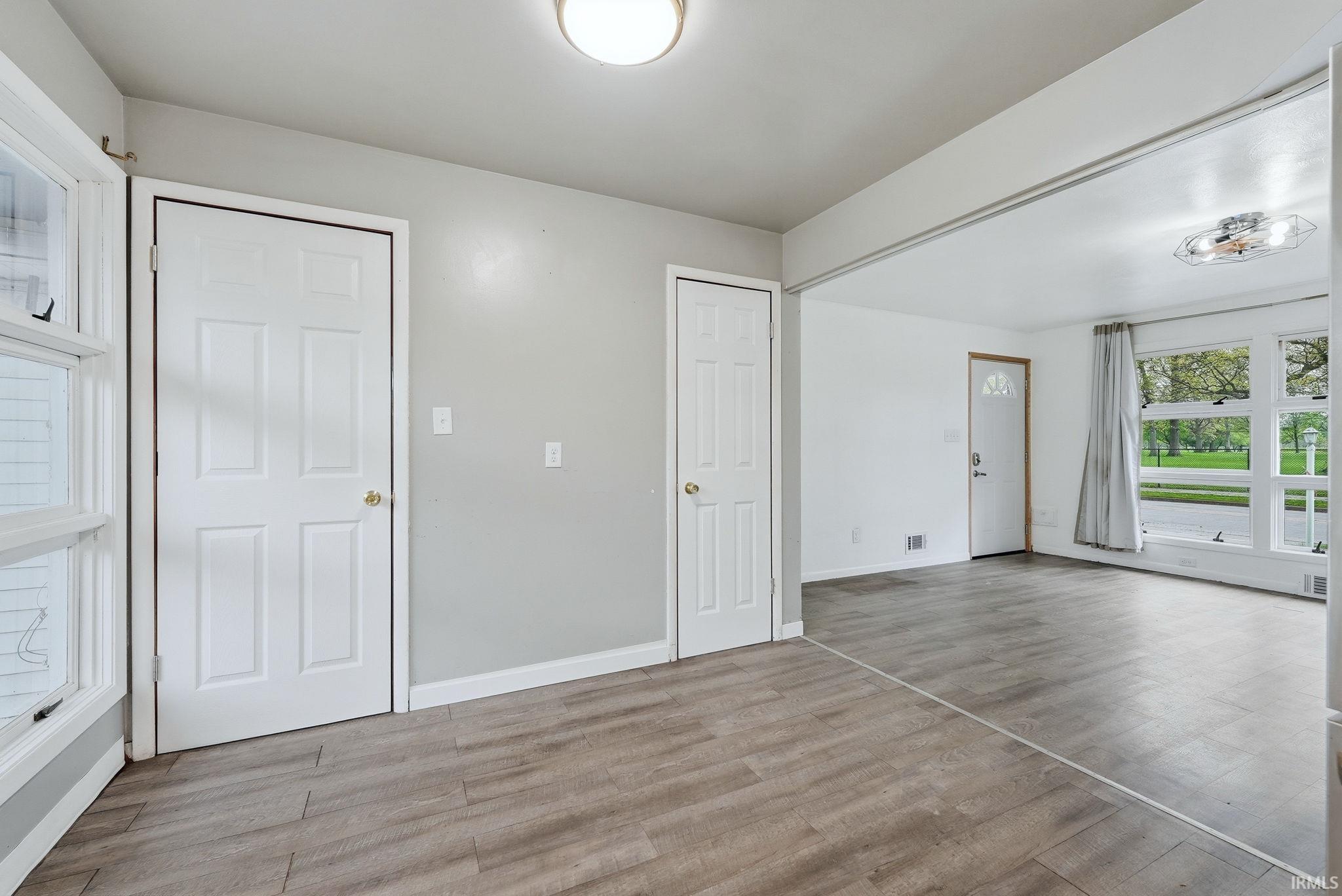 Interior space featuring wood-finish flooring, light gray wall paint, and white trim