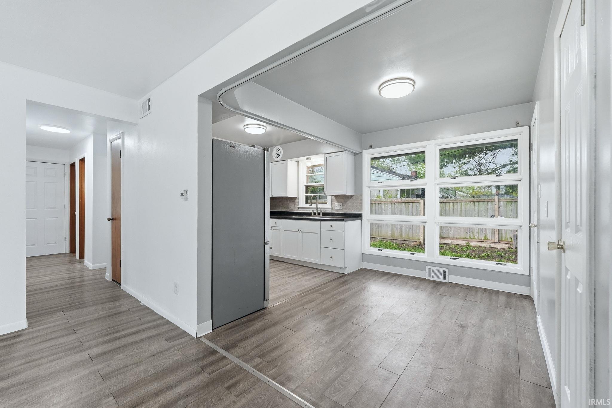 Open-concept living area with wood-finish flooring extending into the kitchen