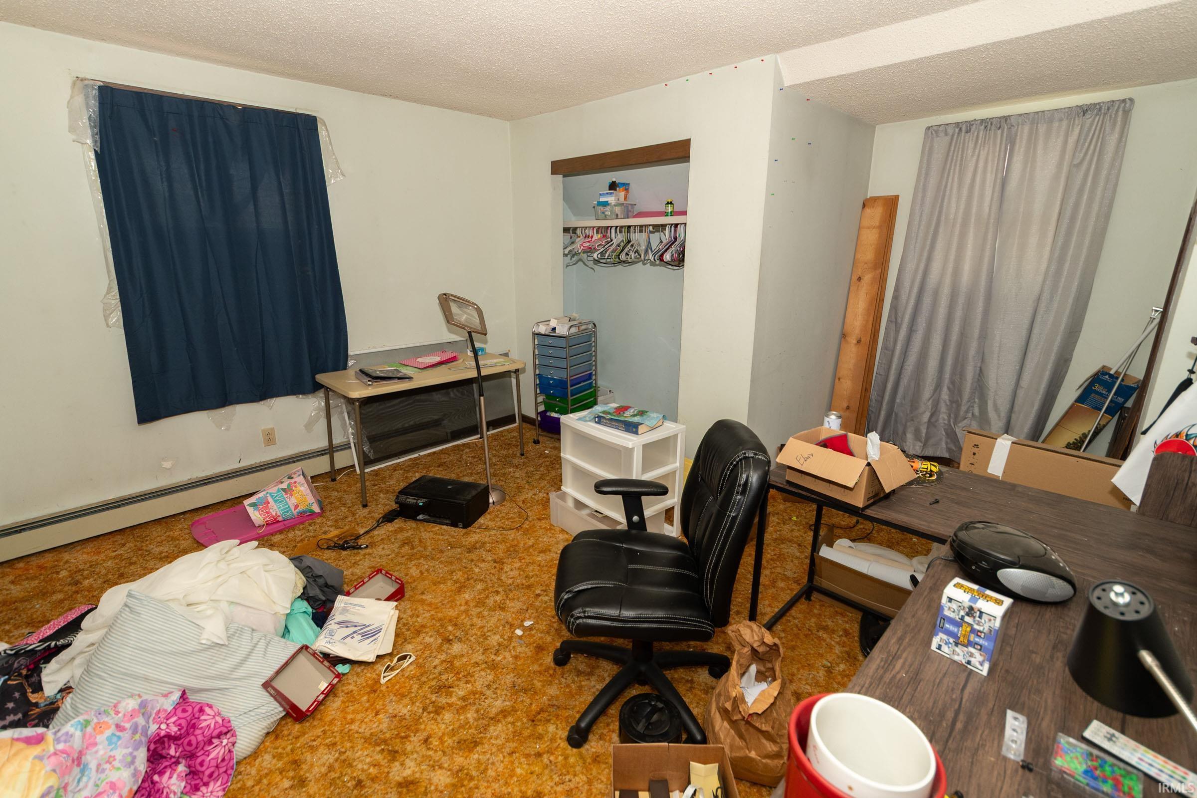Carpeted room featuring a built-in closet with shelving and hanging rod
