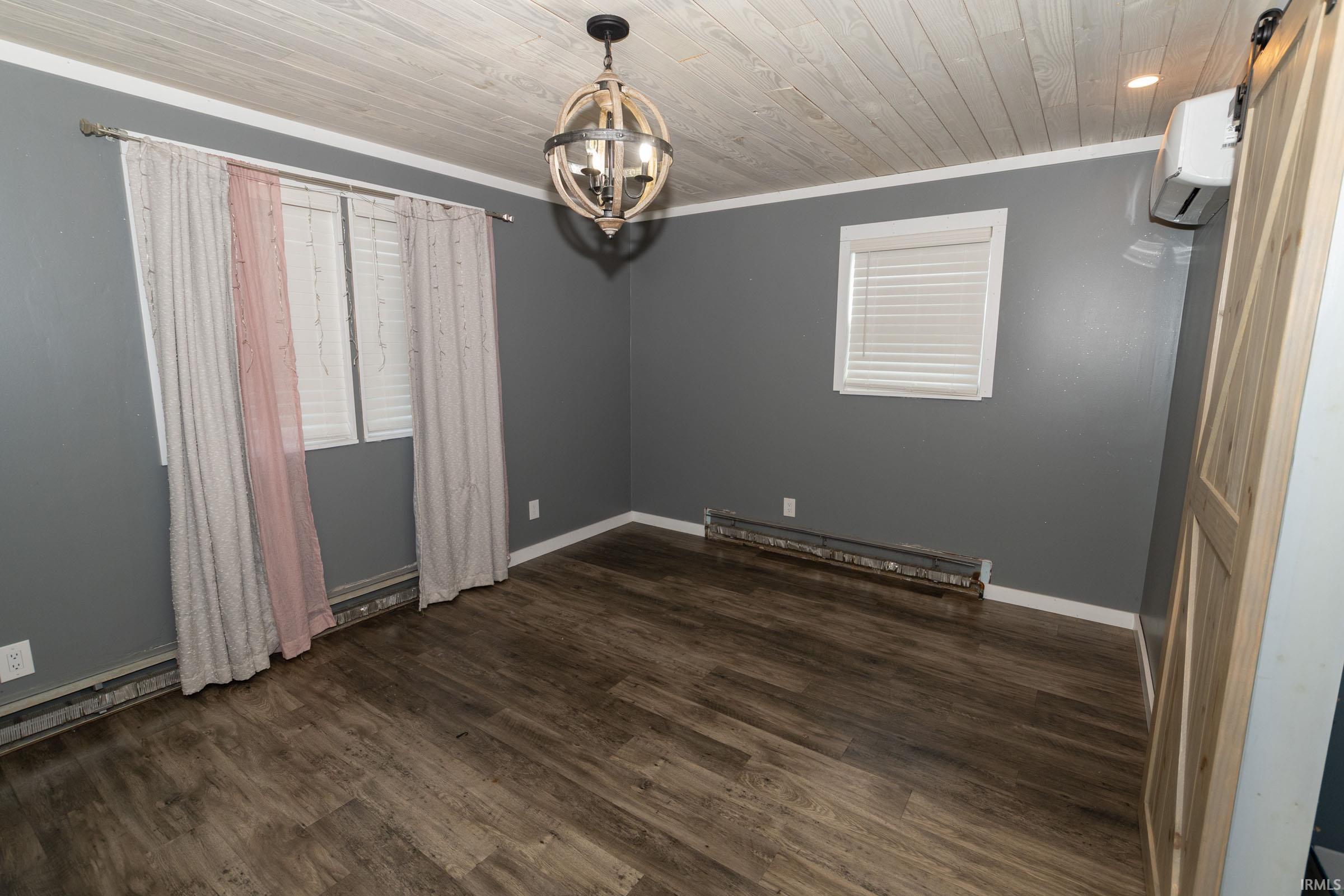 Room featuring wood-finish flooring, a decorative orb chandelier, and a shiplap ceiling