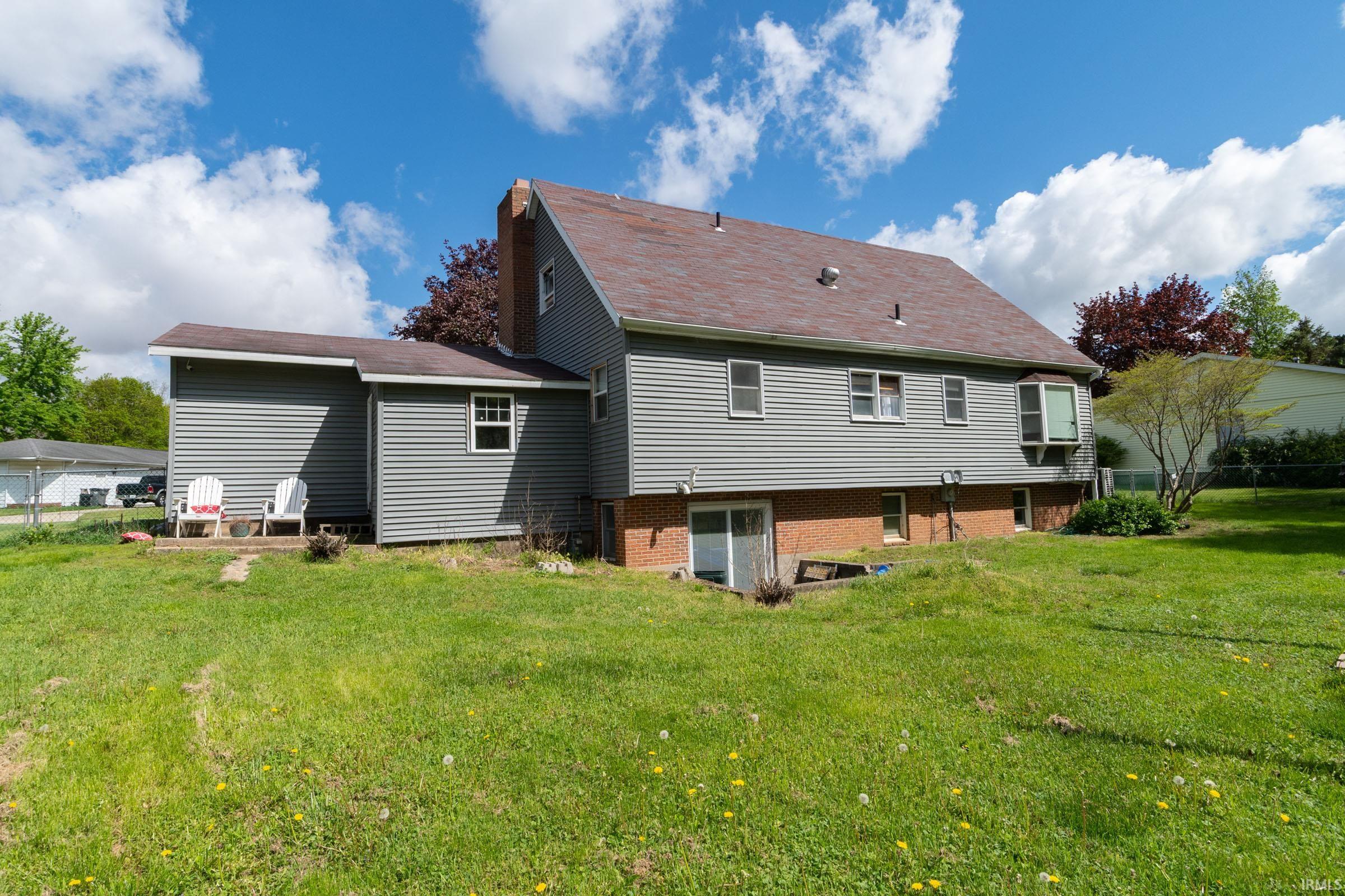 Spacious rear yard with a siding exterior and a brick foundation