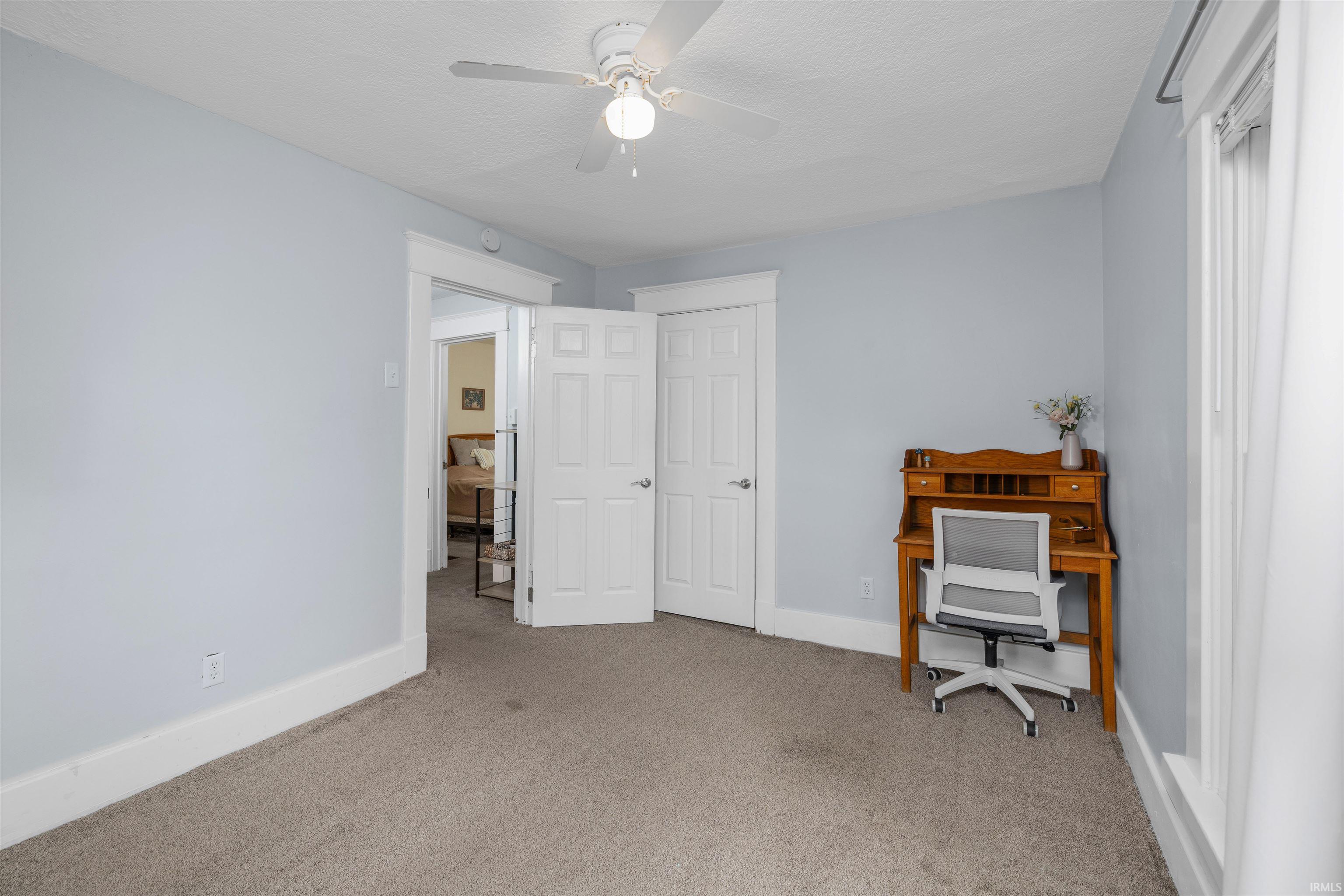 Light gray wall paint, white trim, and neutral carpeting define this versatile interior space