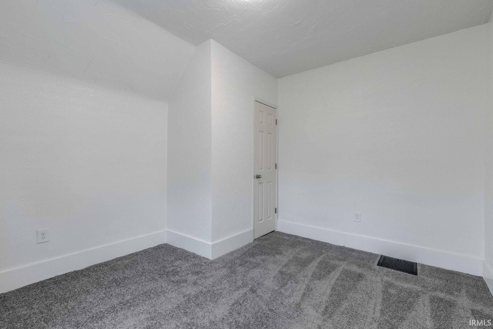 Room featuring light gray carpeting and white walls