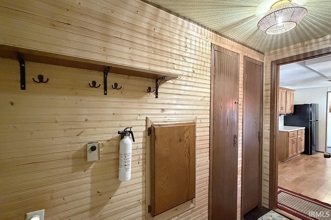 Wood-paneled wall with integrated coat rack and shelving