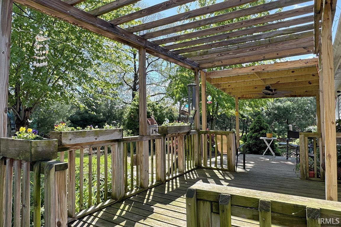 Expansive outdoor deck featuring a wooden pergola and balustrade