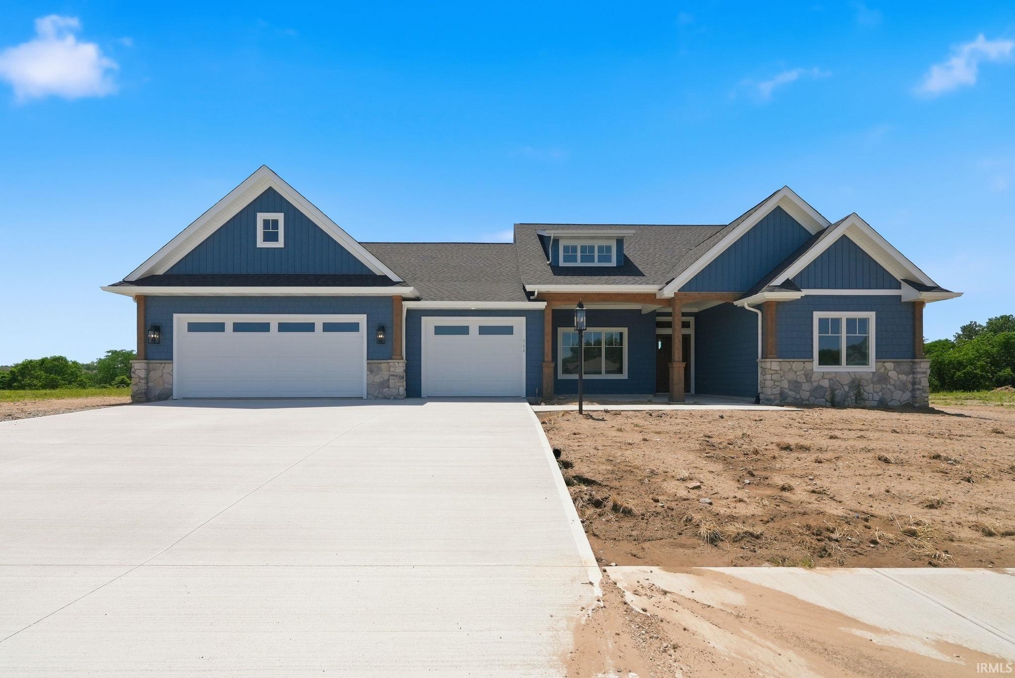 Contemporary ranch-style residence featuring a blue siding exterior with stone accents
