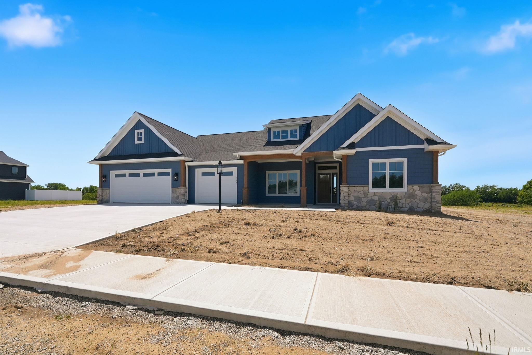 Modern Craftsman exterior featuring blue siding, stone accents, and a dark shingle roof