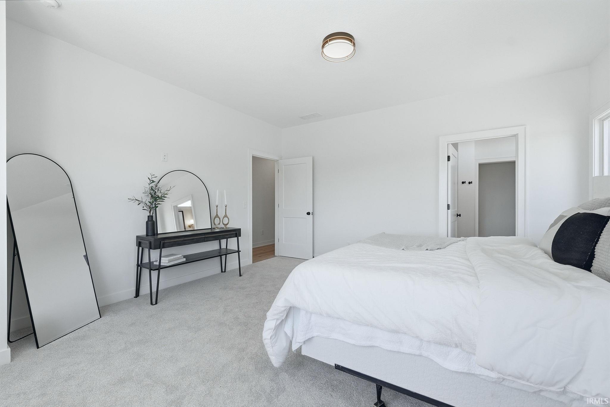 Bright interior space featuring white walls and light-toned carpeting