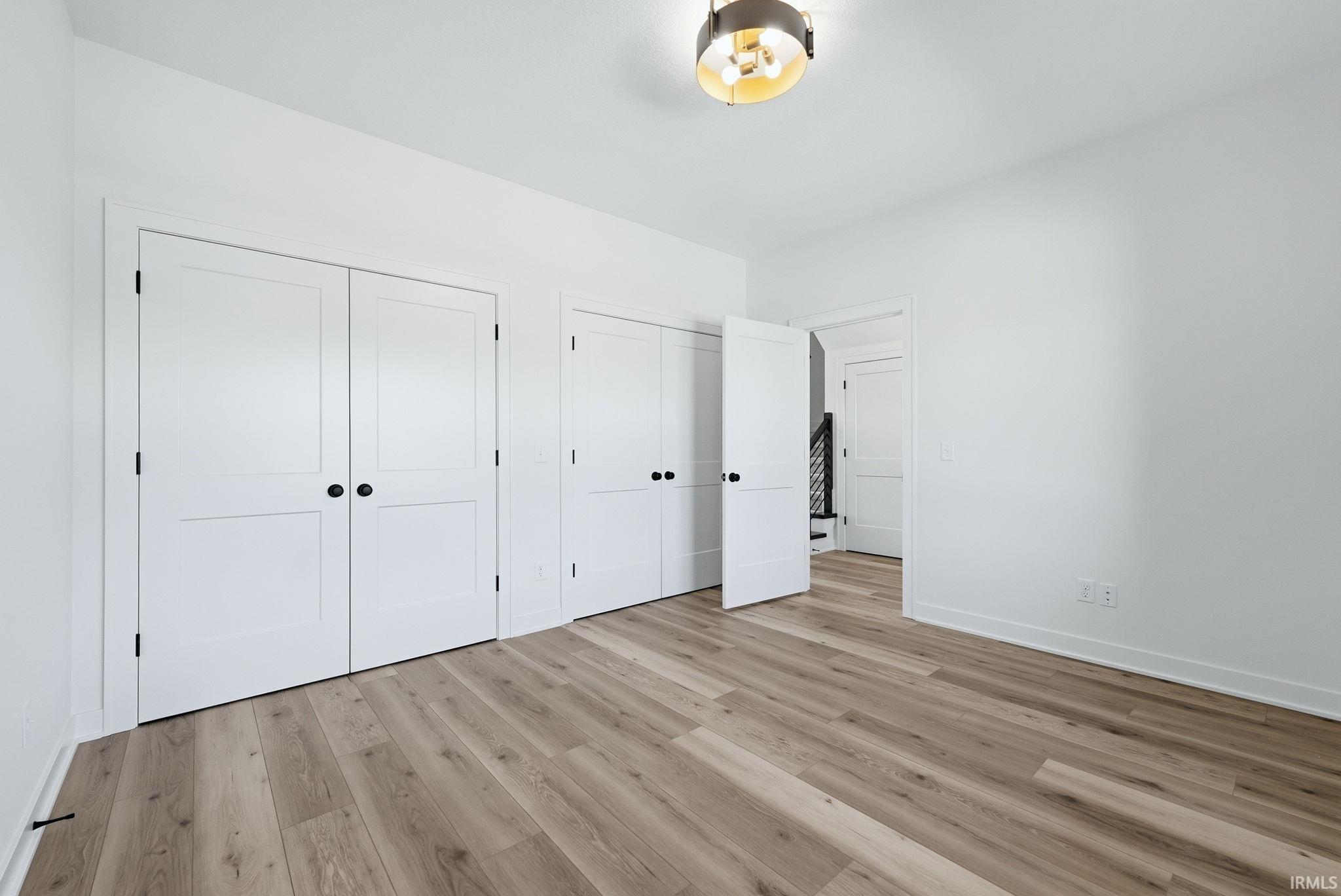 Light wood-finish flooring complements crisp white walls in this interior space