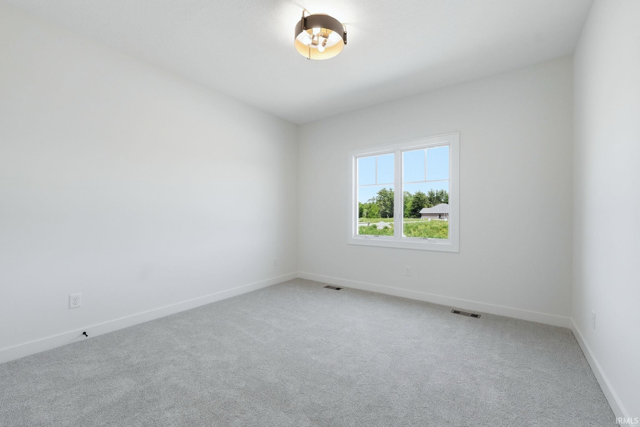 Room with neutral wall paint and light gray carpeting