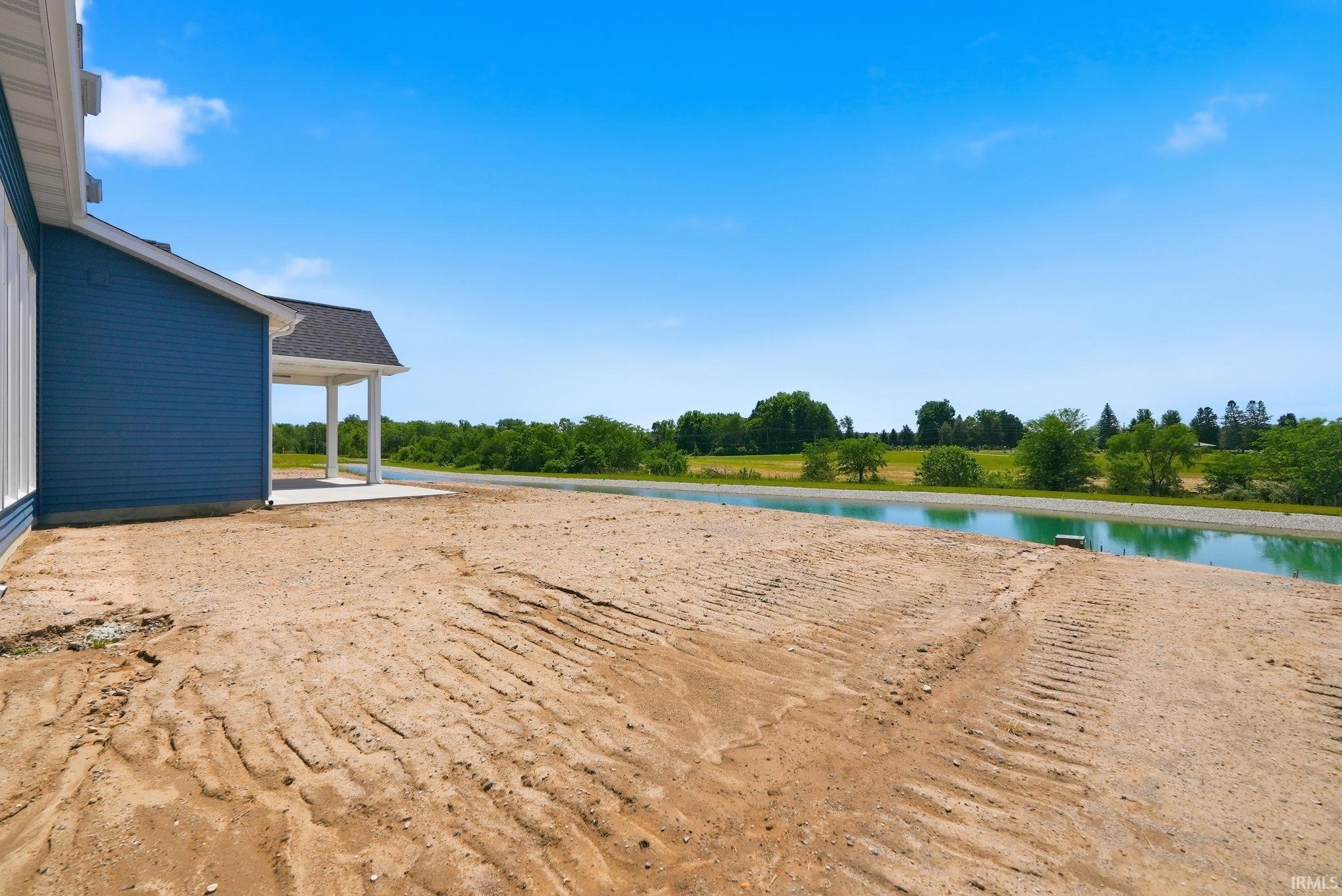 Expansive undeveloped land bordering a water feature and tree line