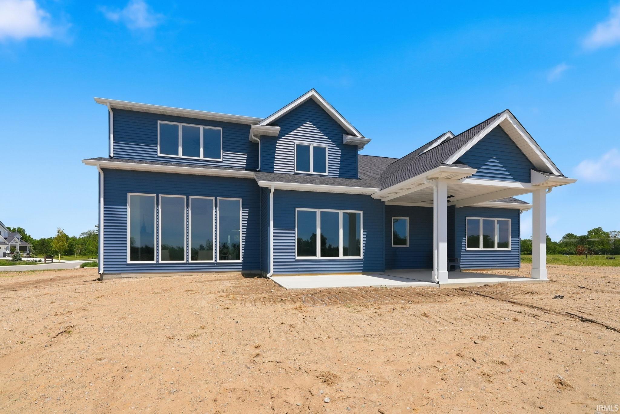 Modern two-story residence with blue horizontal siding, white trim, and a dark shingle roof
