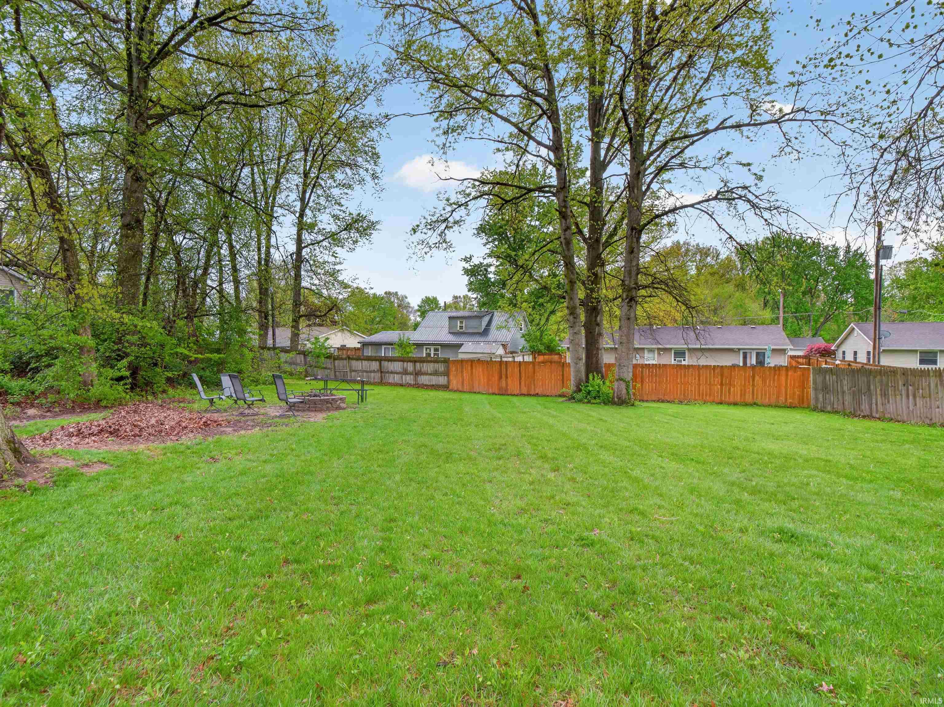 Expansive green lawn surrounded by mature trees