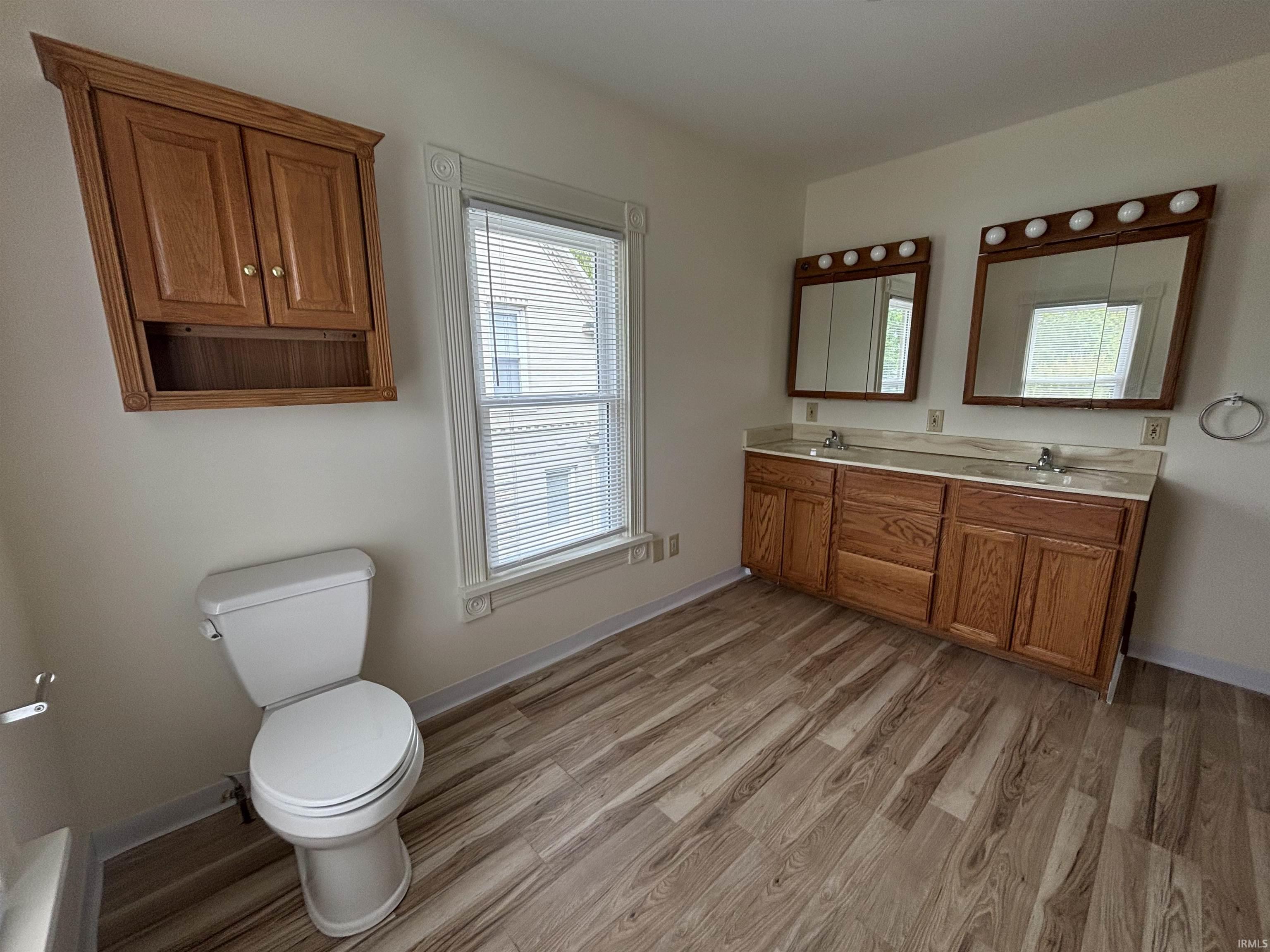 Spacious bathroom featuring wood-finish flooring and a double vanity with ample storage