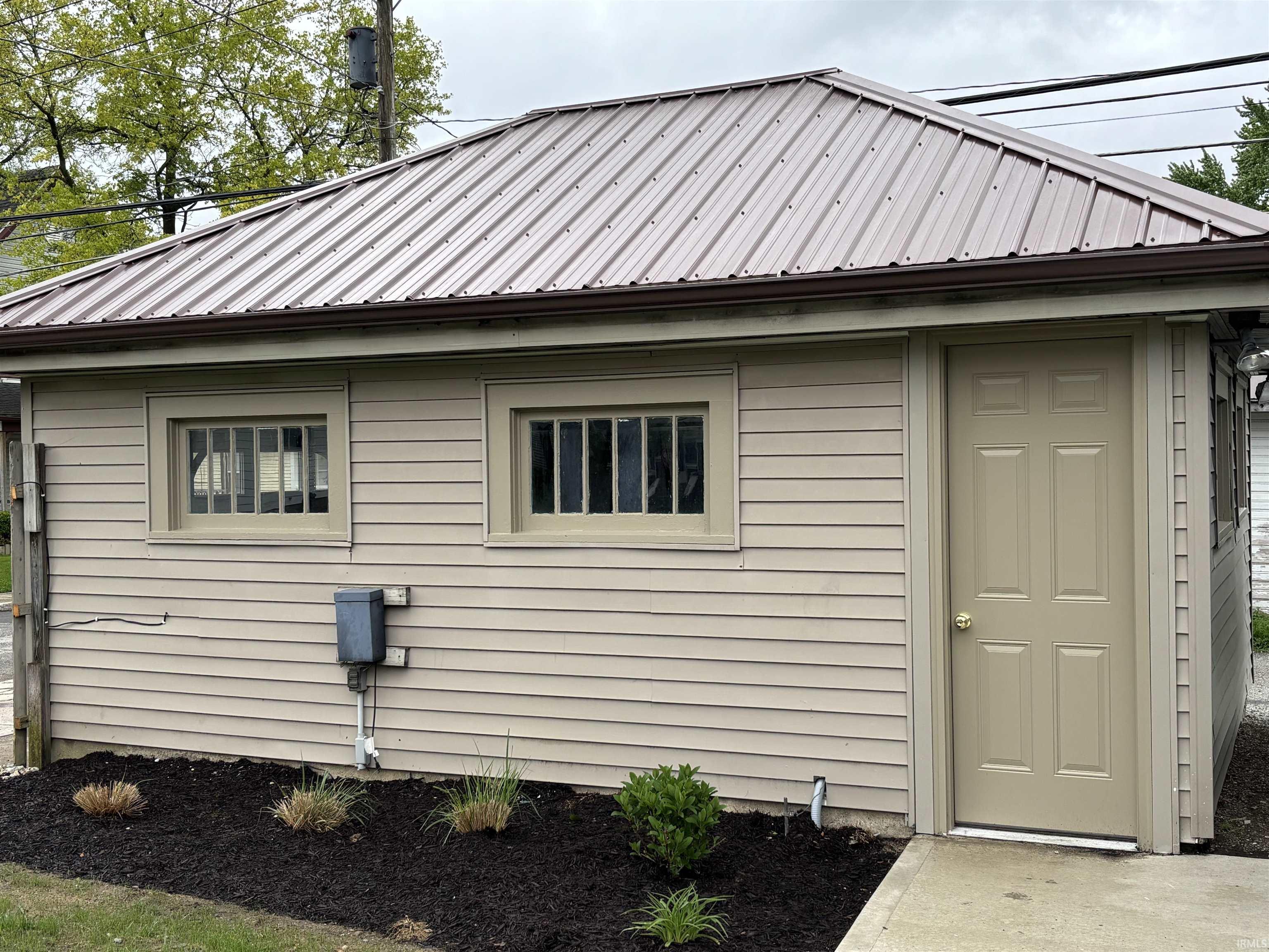 Detached garage featuring a metal roof, horizontal siding