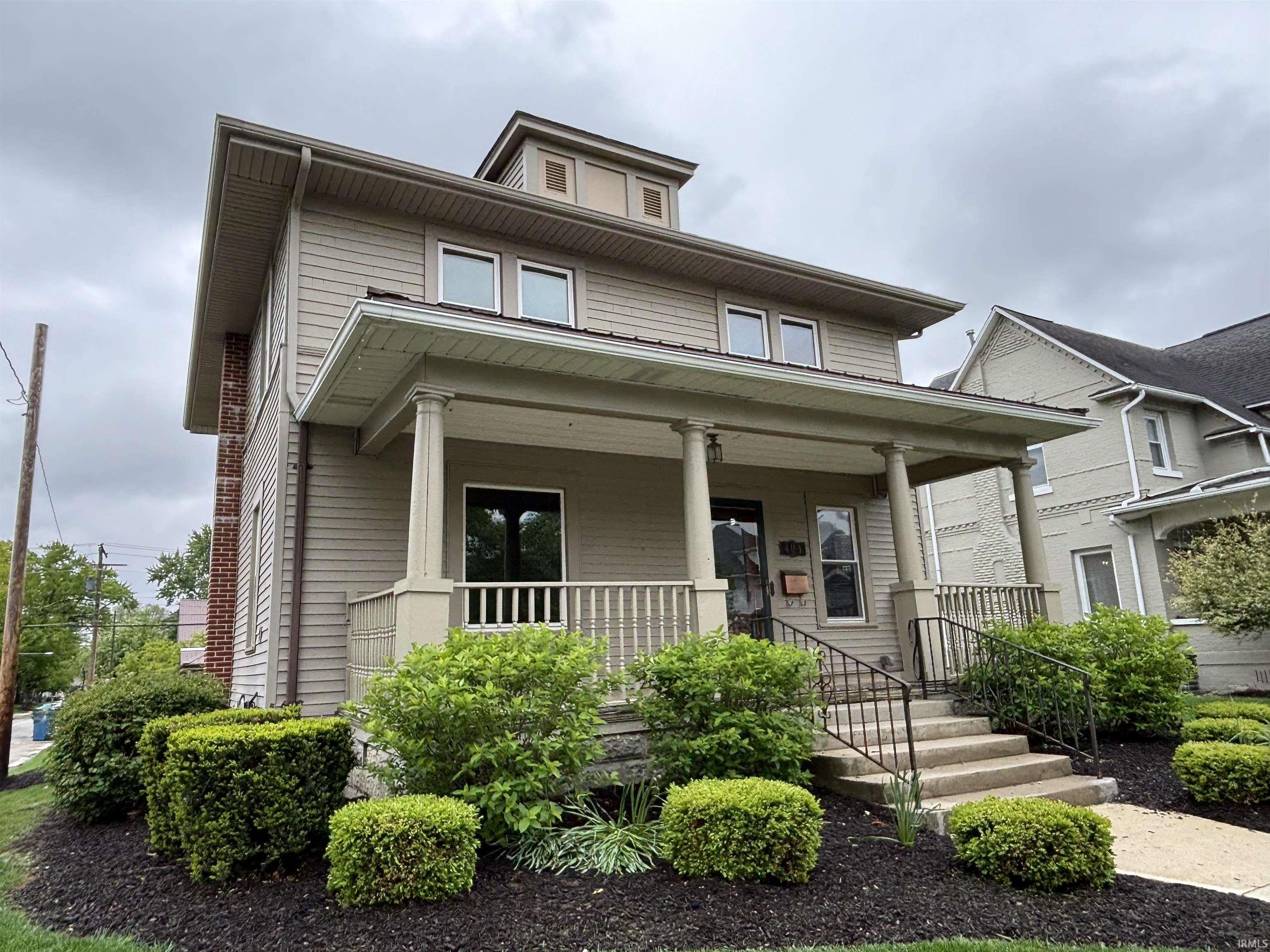 Traditional architecture with a covered front porch featuring round columns