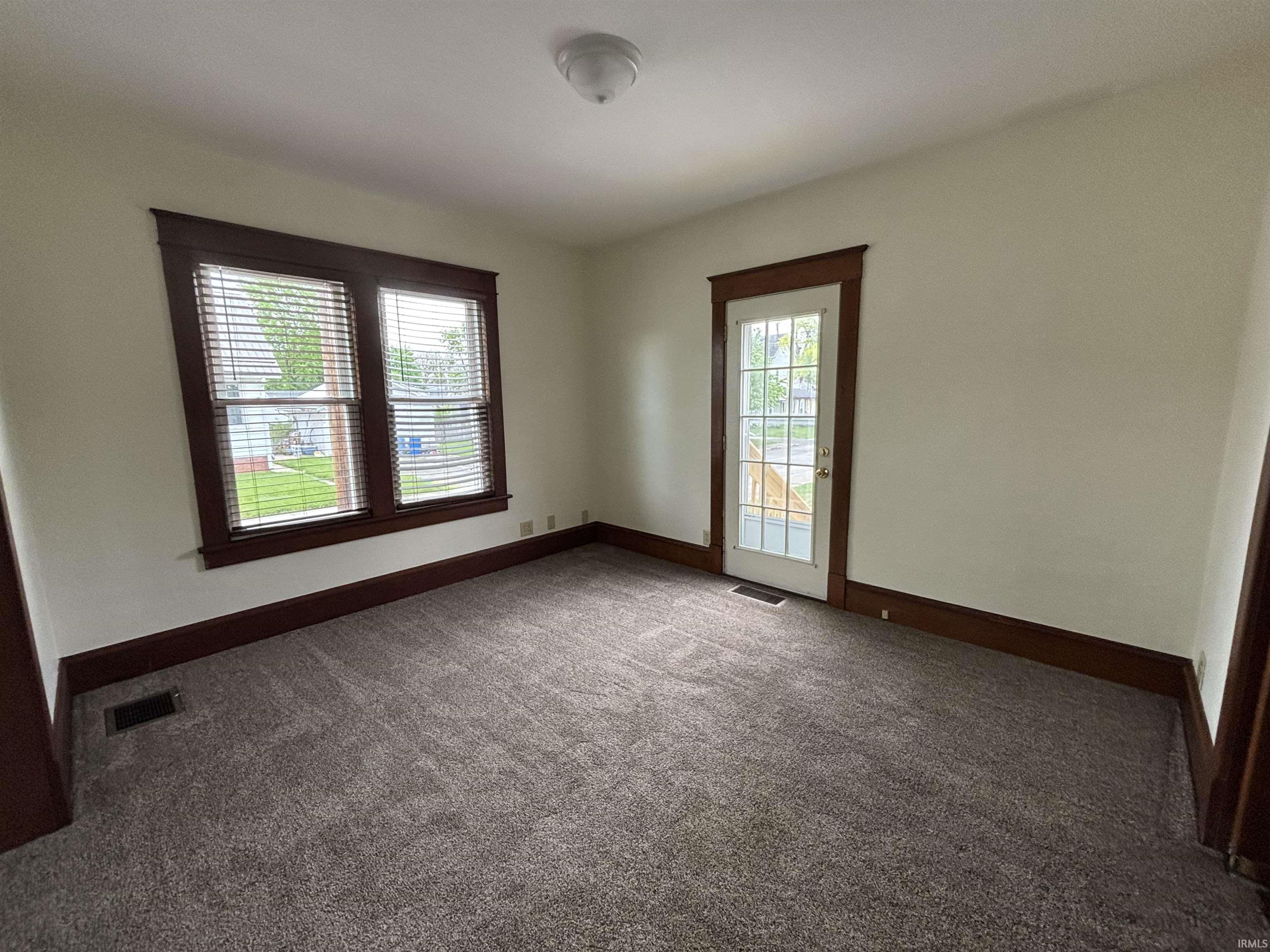 Dining room with neutral walls and tan carpeting
