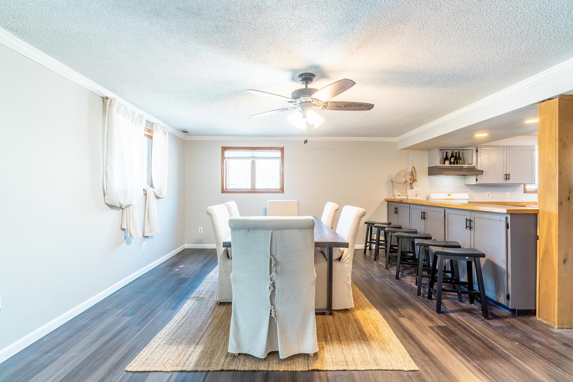 Spacious dining area featuring wood-finish flooring, a ceiling fan, and recessed lighting