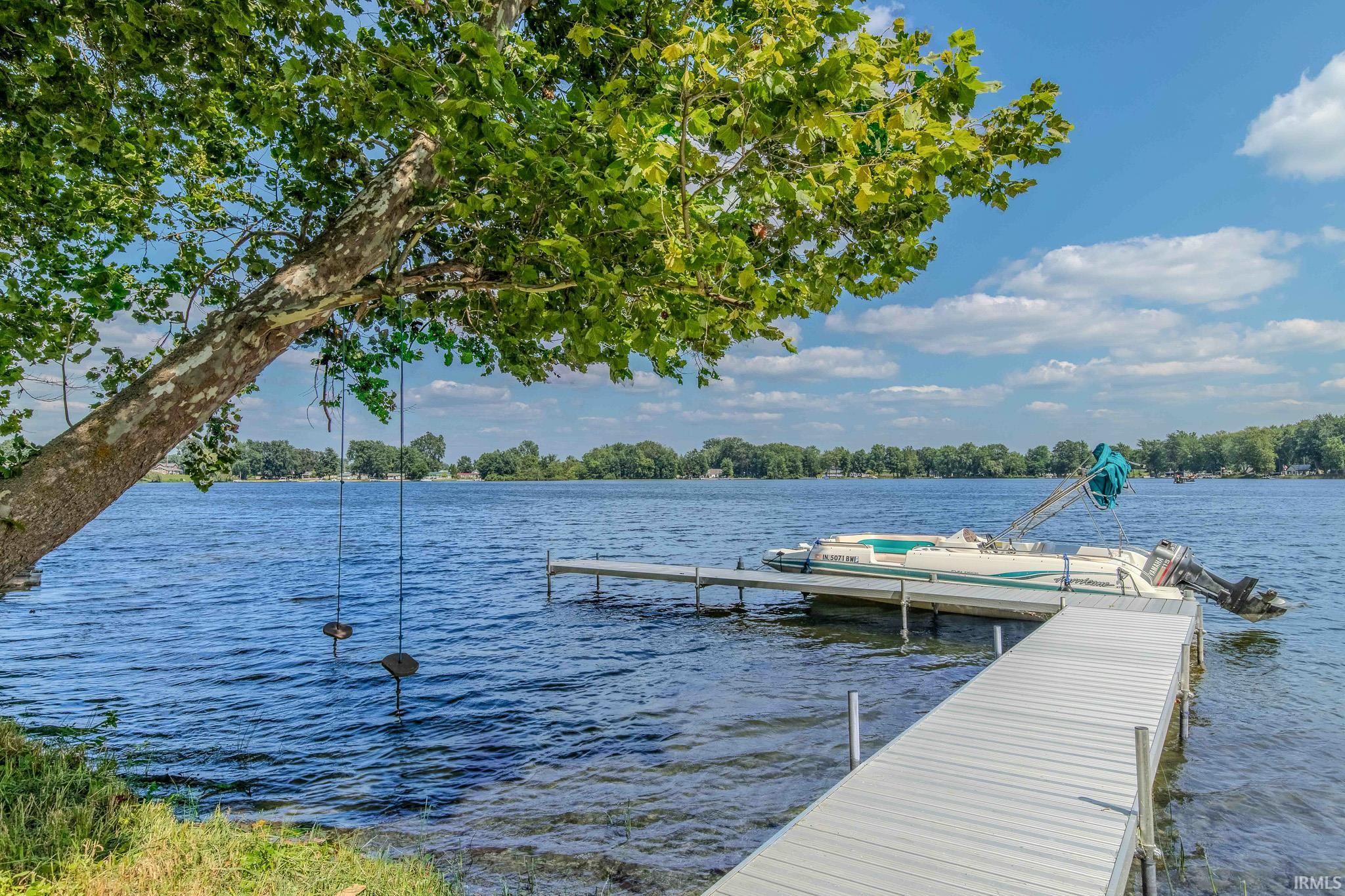 Waterfront property featuring a private dock and mature trees