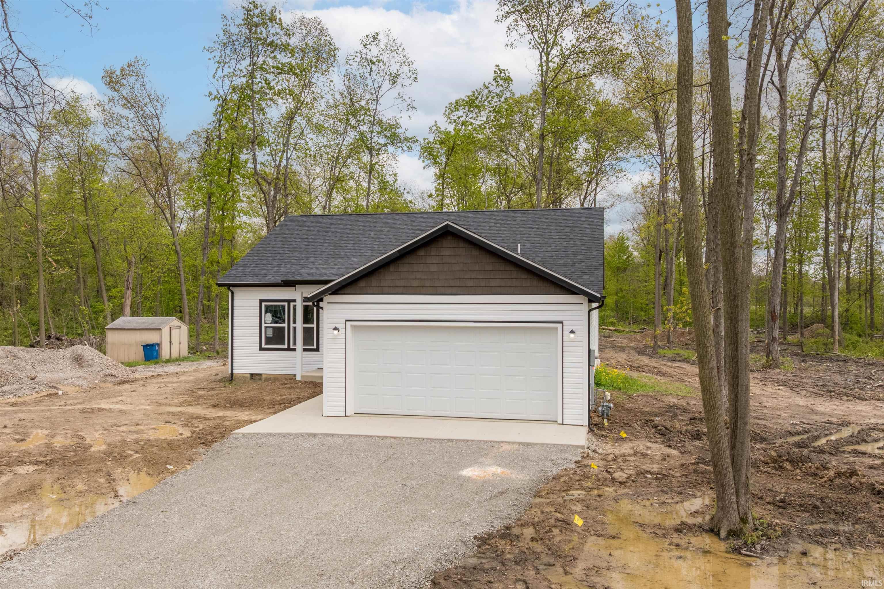 Newly constructed residence featuring white siding with dark trim accents and a dark shingle roof