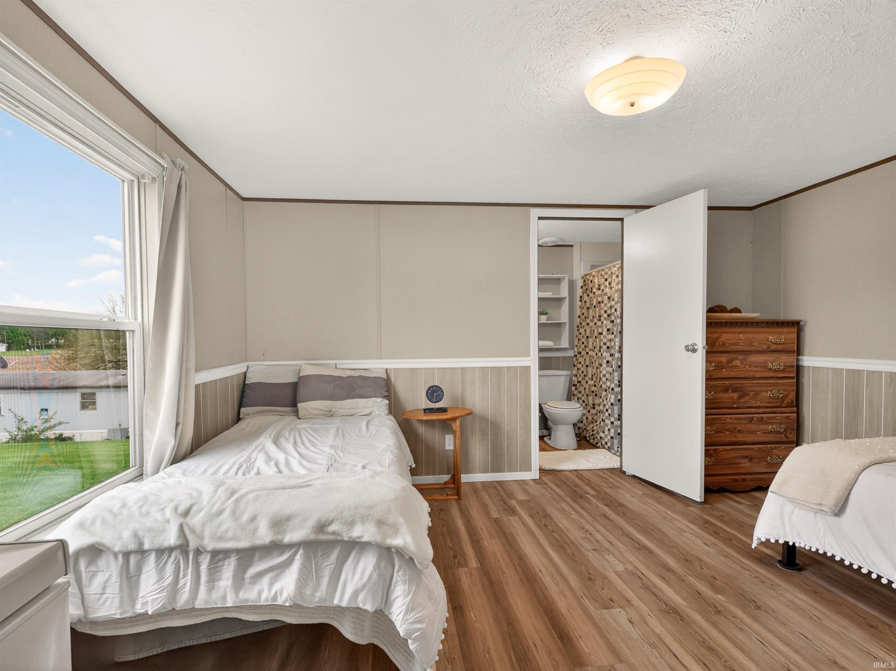 Spacious room with wood-finish flooring and wainscoting