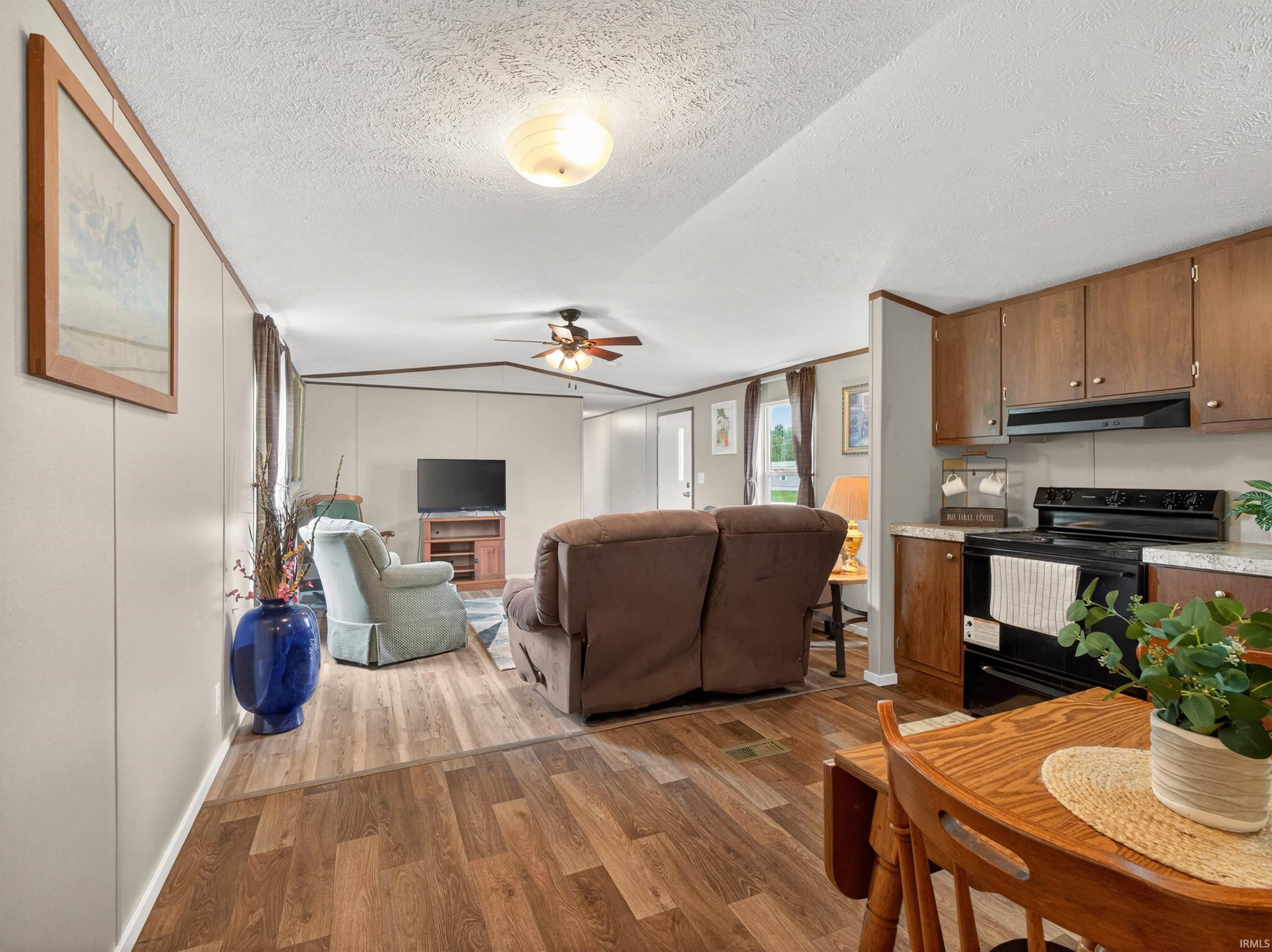 Open concept living area featuring wood-finish flooring, a ceiling fan, and recessed lighting