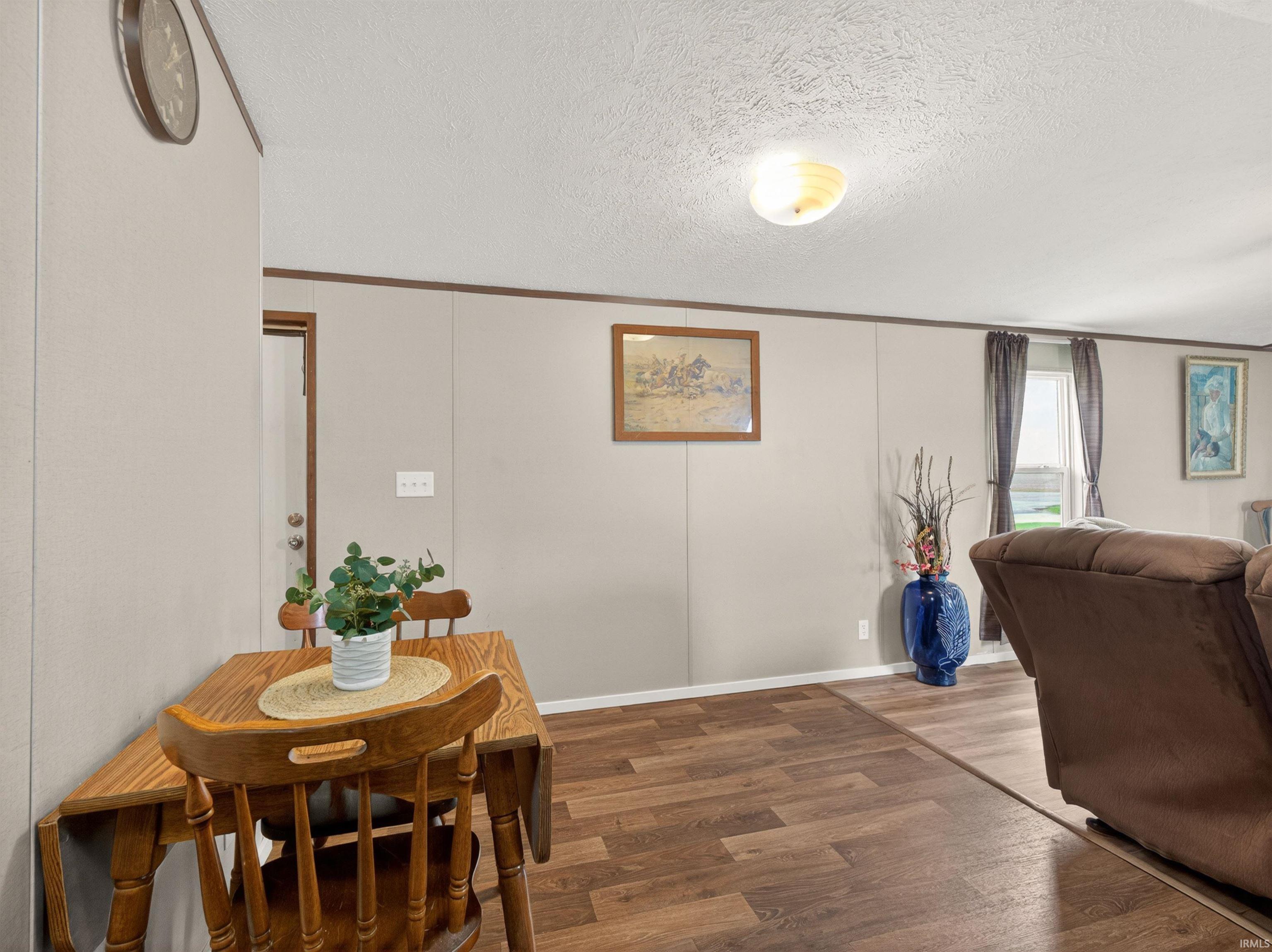 Dining area featuring wood-finish flooring, light neutral-toned walls, and a ceiling-mounted light fixture