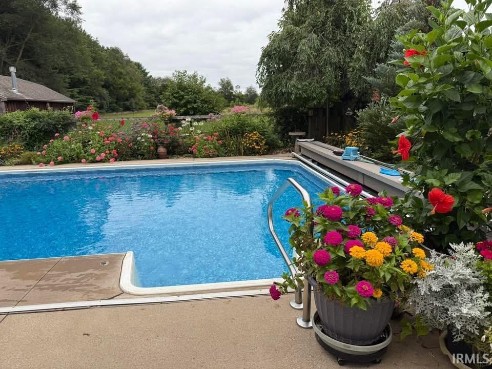 Outdoor swimming pool with integrated entry steps and perimeter concrete decking