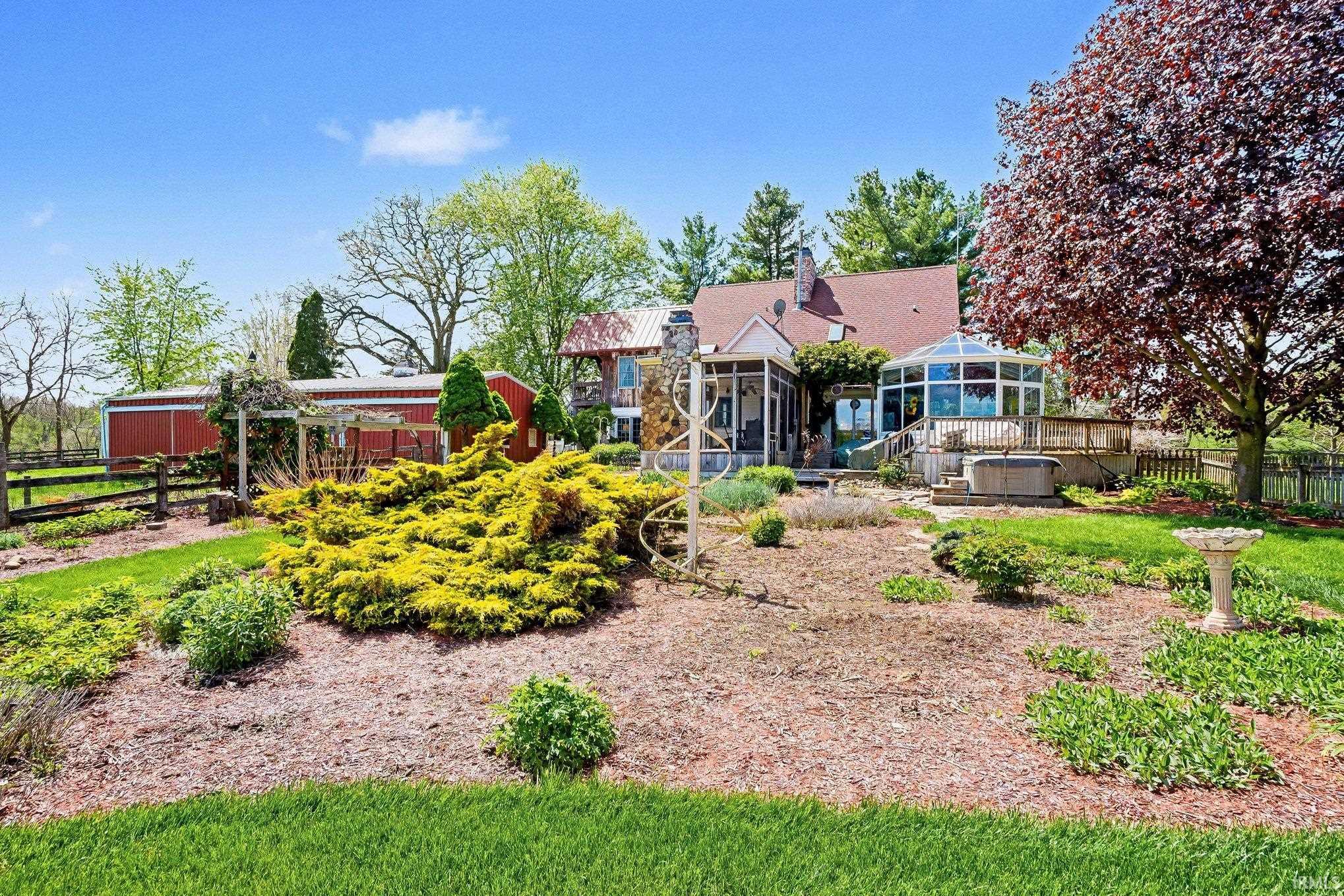 Expansive backyard featuring a large sunroom, wood deck, and built-in hot tub