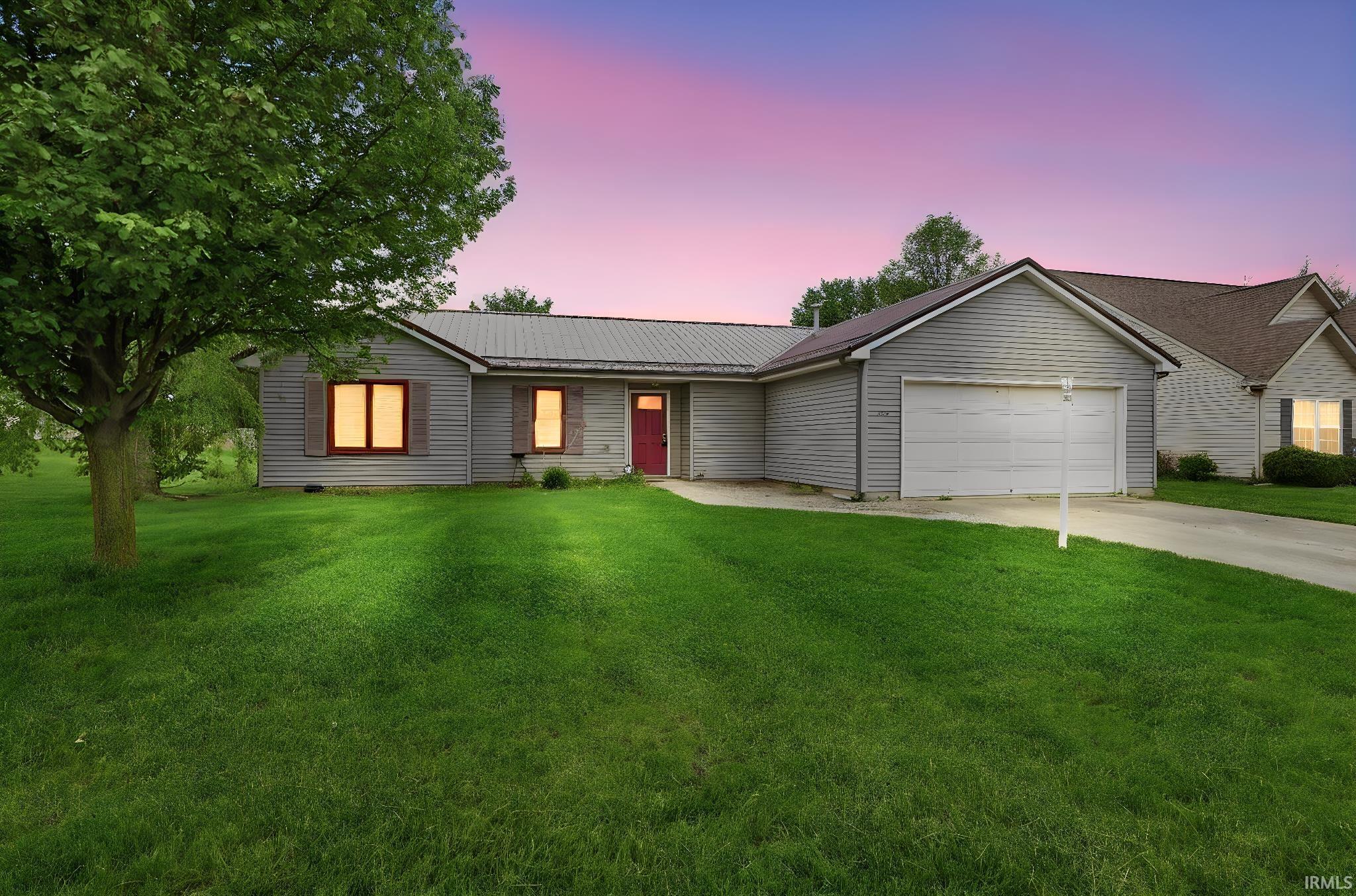 Single-story residence featuring light gray siding and a metal roof