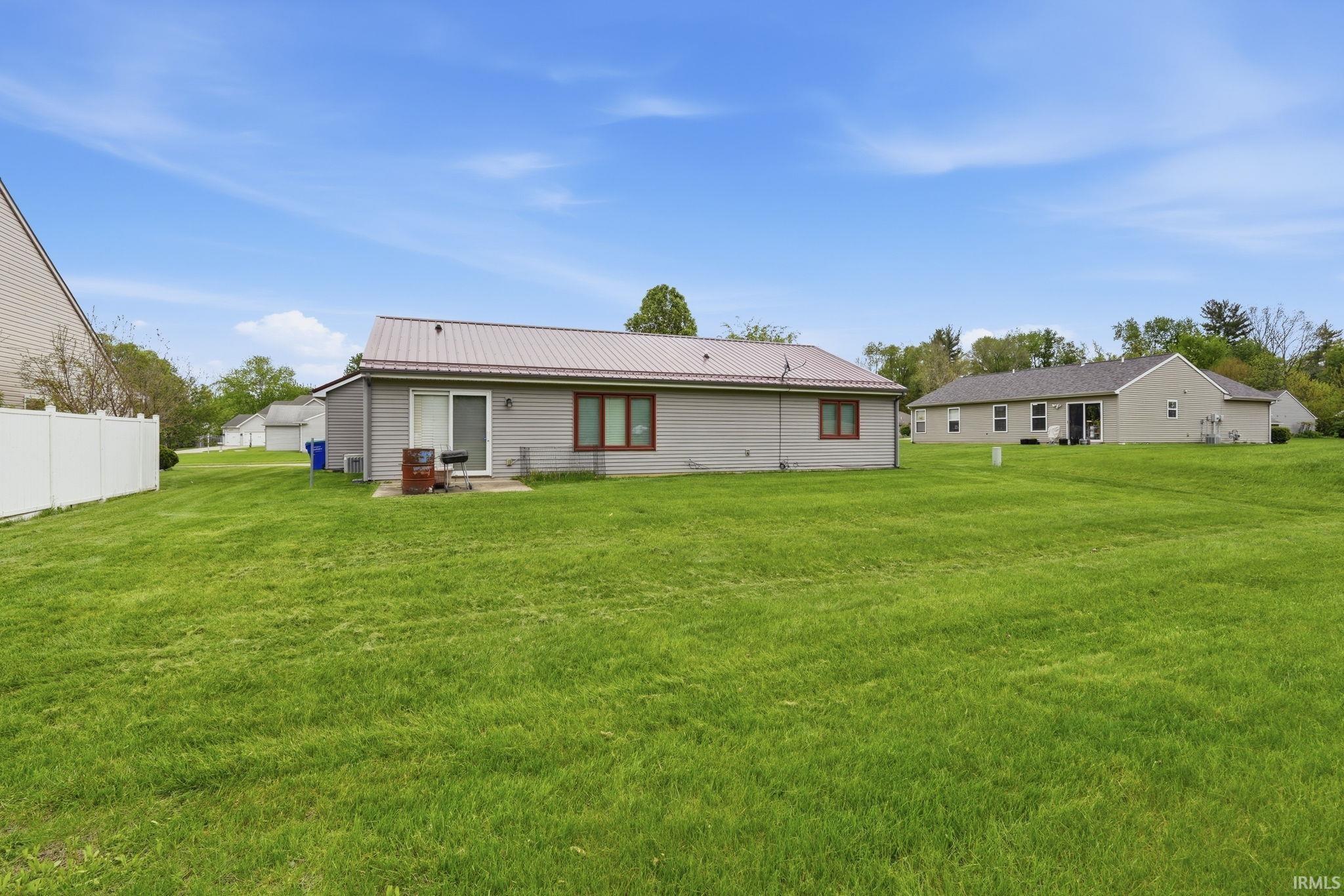 Expansive green lawn with a vinyl privacy fence