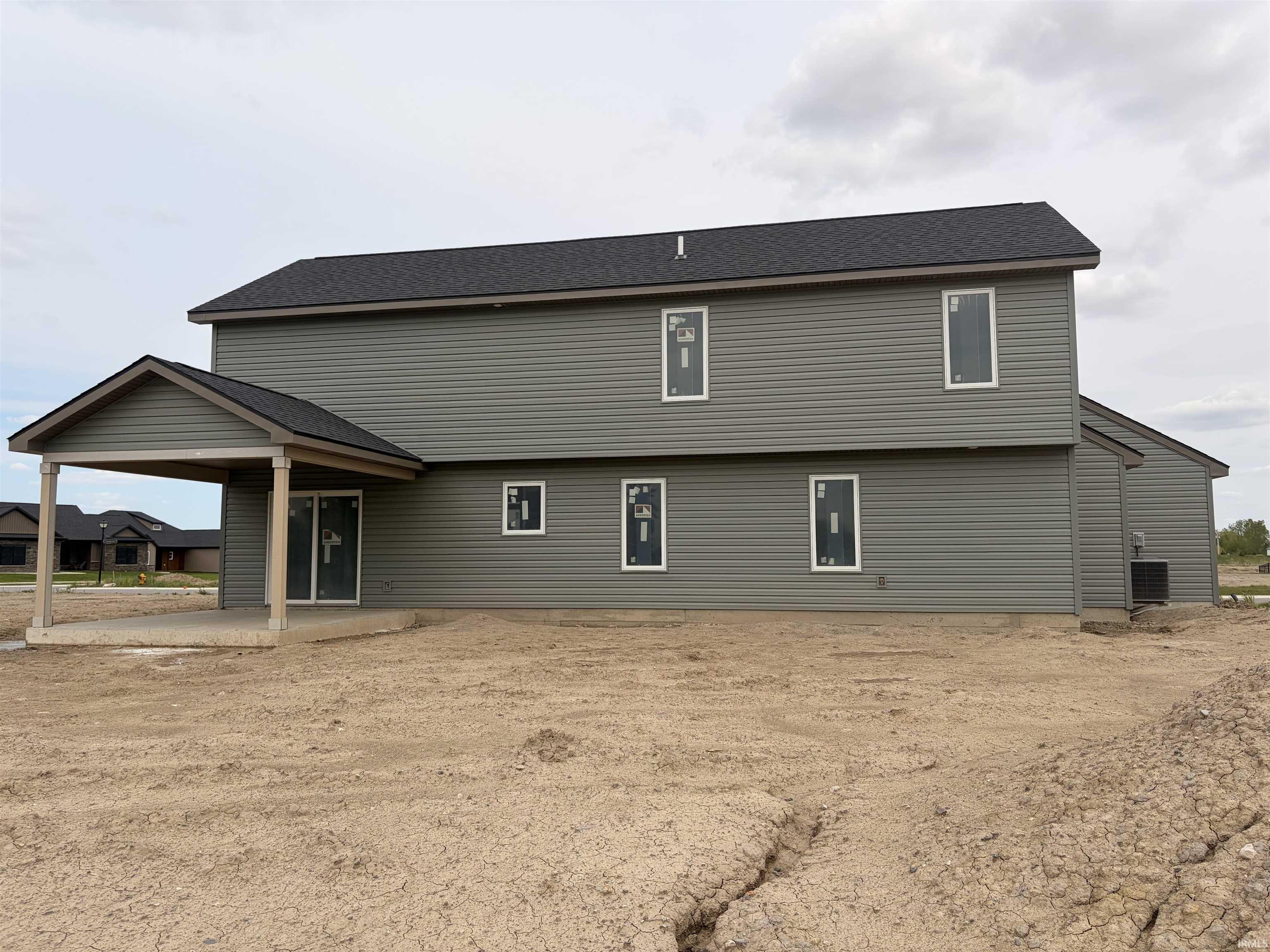 Two-story residence featuring grey horizontal siding and a dark shingle roof