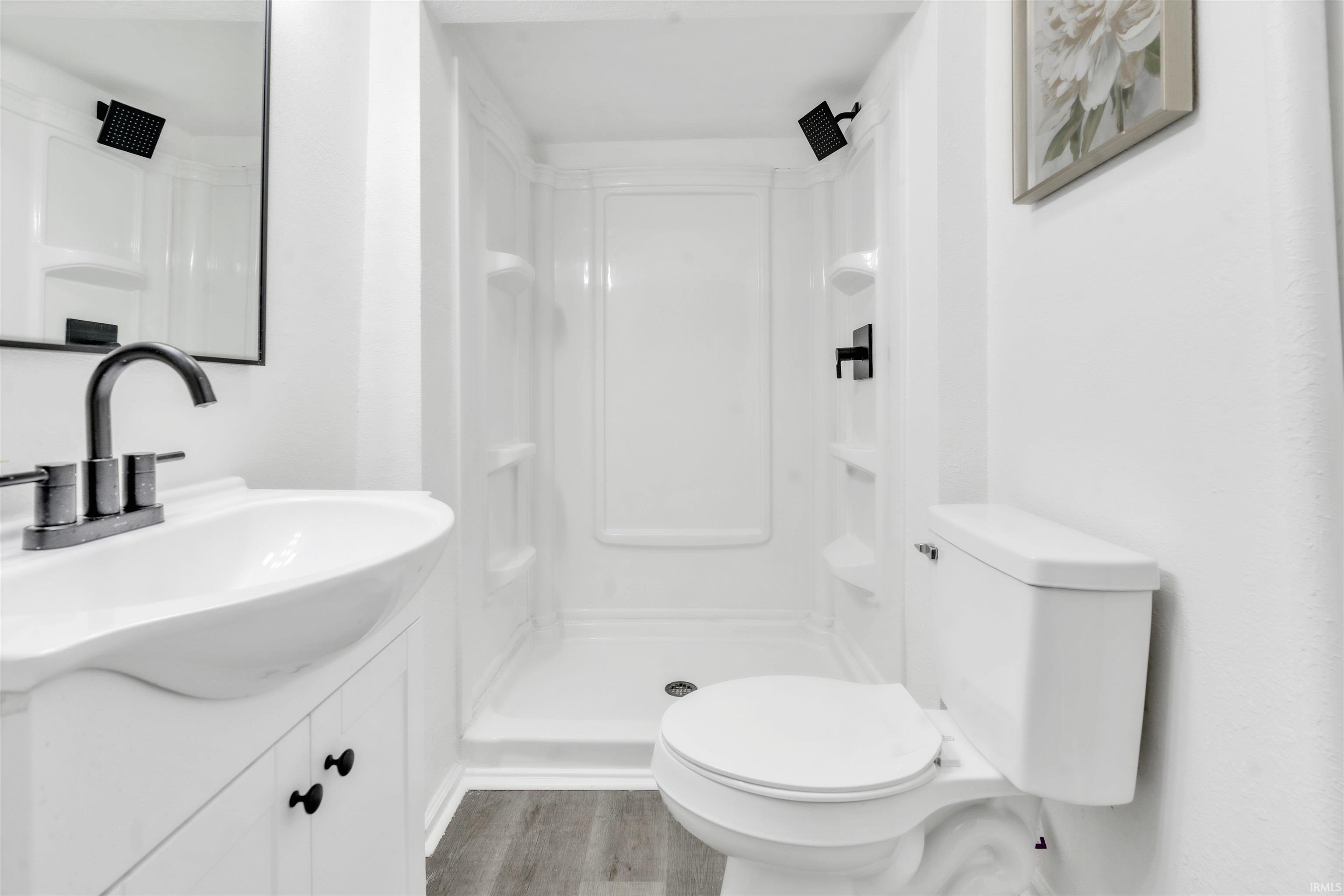 Bathroom featuring a white vanity with integrated sink, matte black faucet, and coordinating hardware