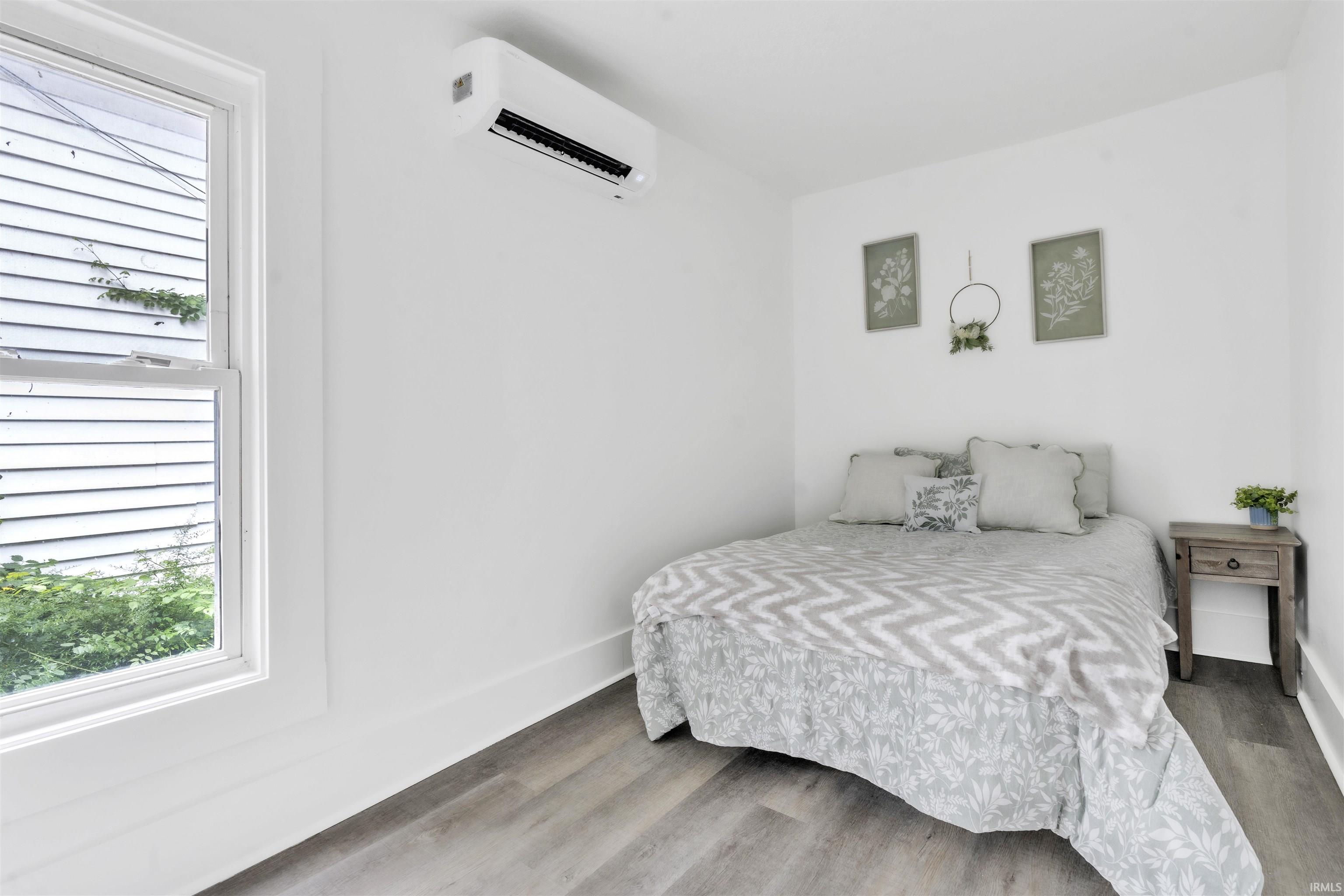 White walls, wood-finish flooring, and a single window with white trim