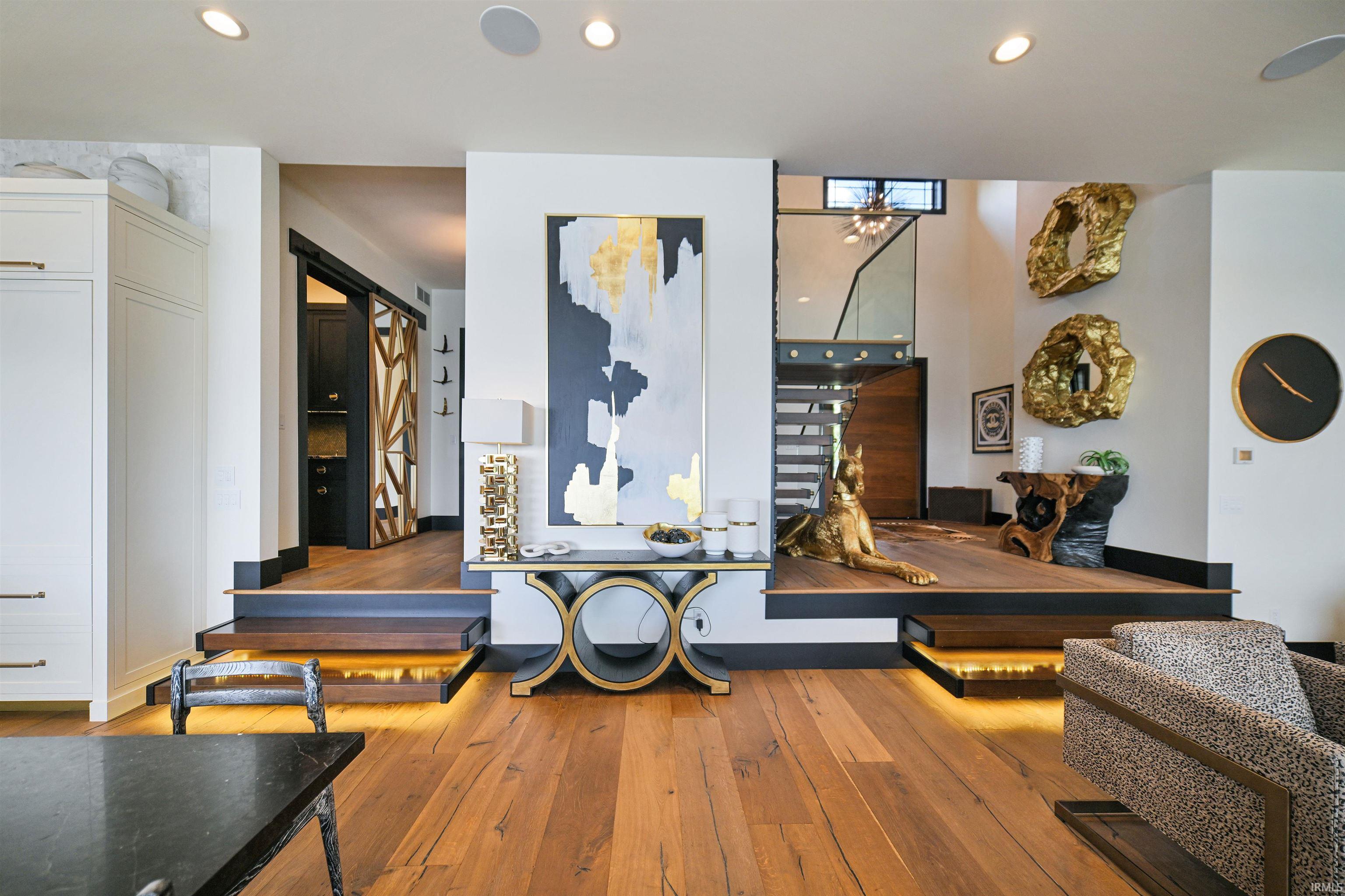 Open-concept interior featuring wood-finish flooring, recessed lighting, and a multi-level design