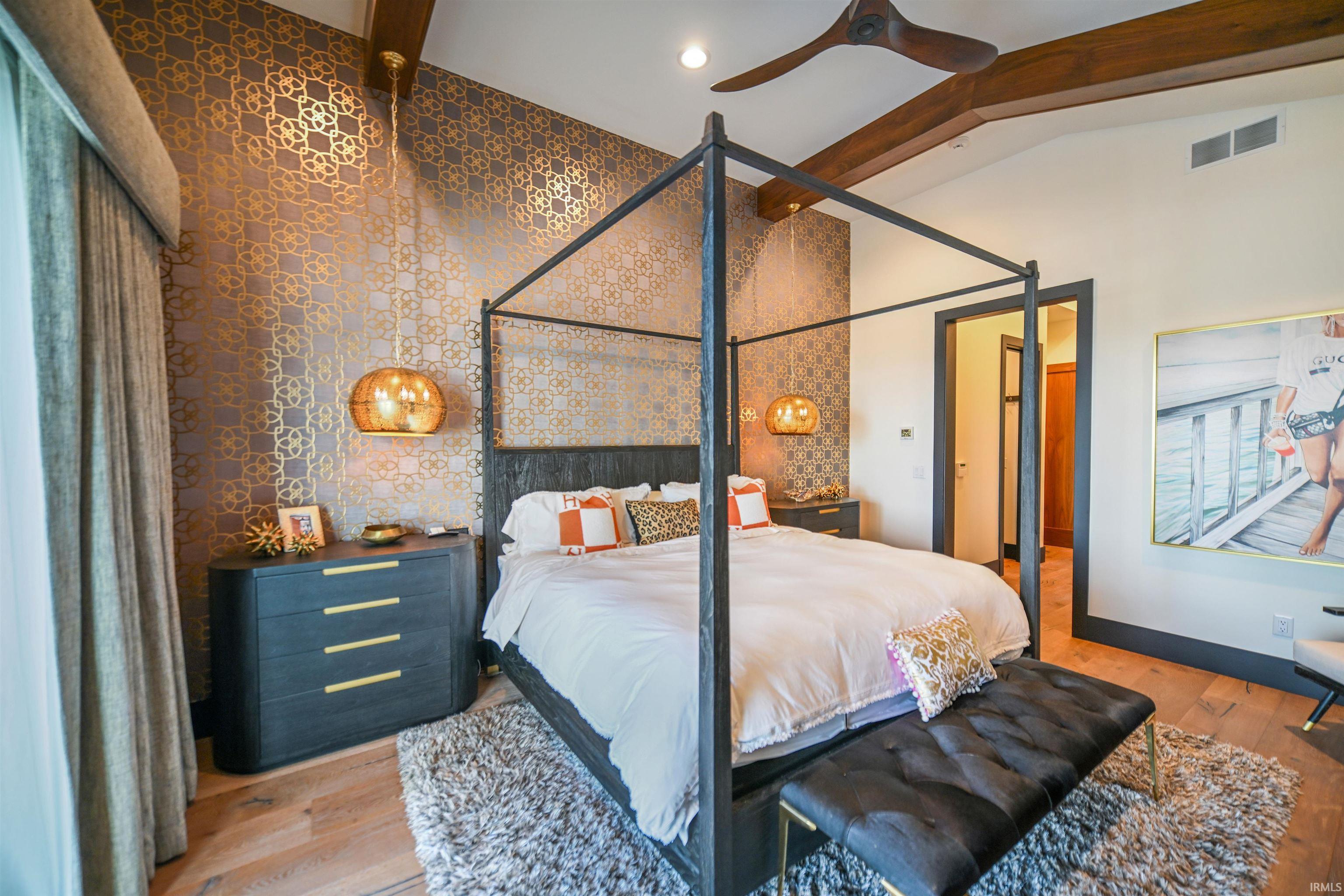 Vaulted ceiling featuring exposed wood beams and a contemporary ceiling fan
