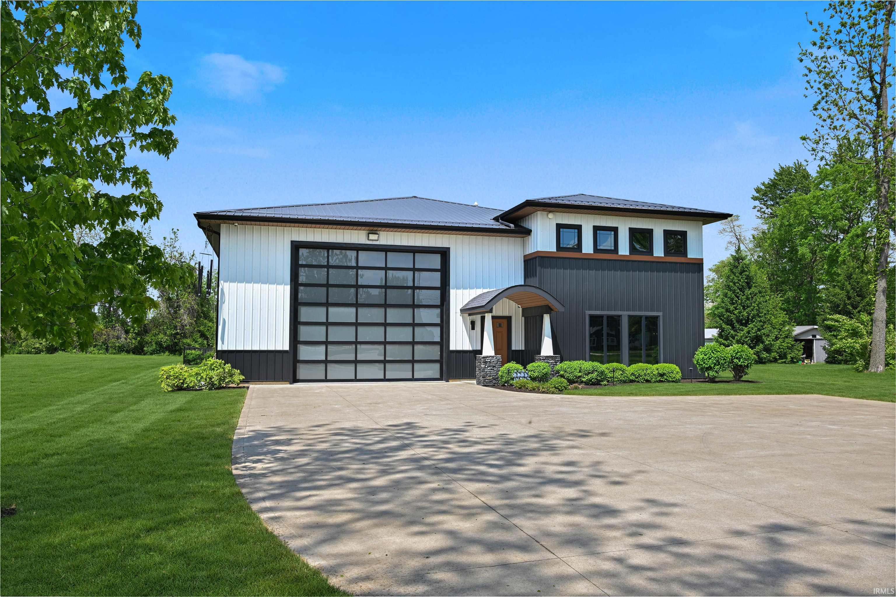 Contemporary structure featuring white vertical siding and dark gray paneling